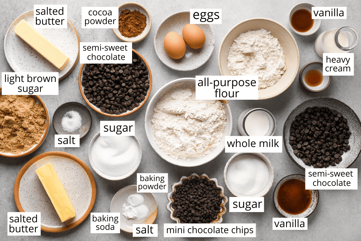 overhead photo of the ingredients in this cookie dough brownies recipe all in bowls and labeled like flour, chocolate chips, butter, cocoa powder, sugar, etc. 