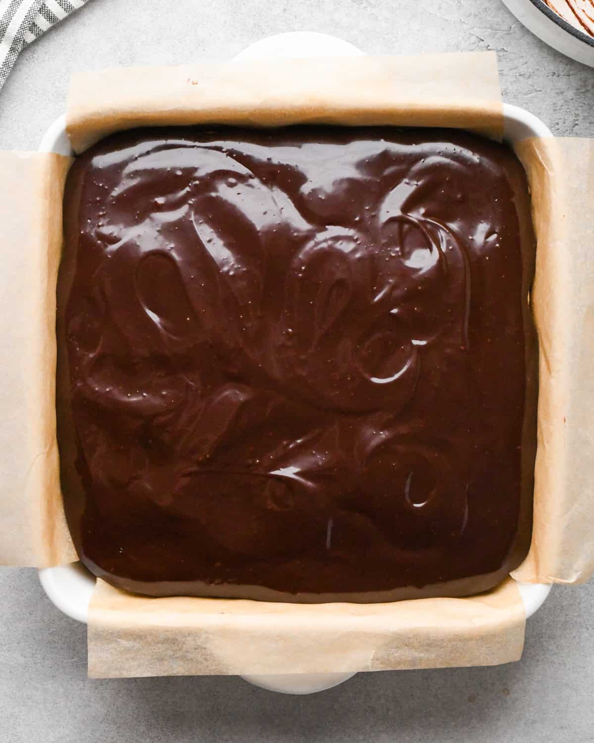 assembling cookie dough brownies - chocolate ganache spread over the cookie dough layer