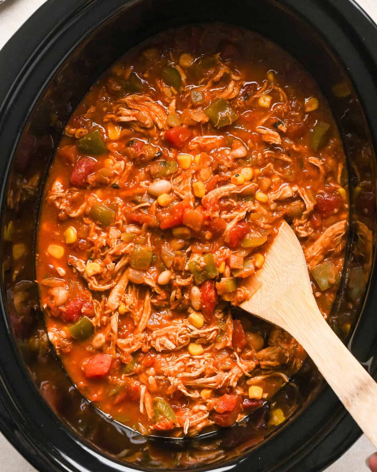 Slow Cooker Chicken Chili in a crock pot with a wooden spatula