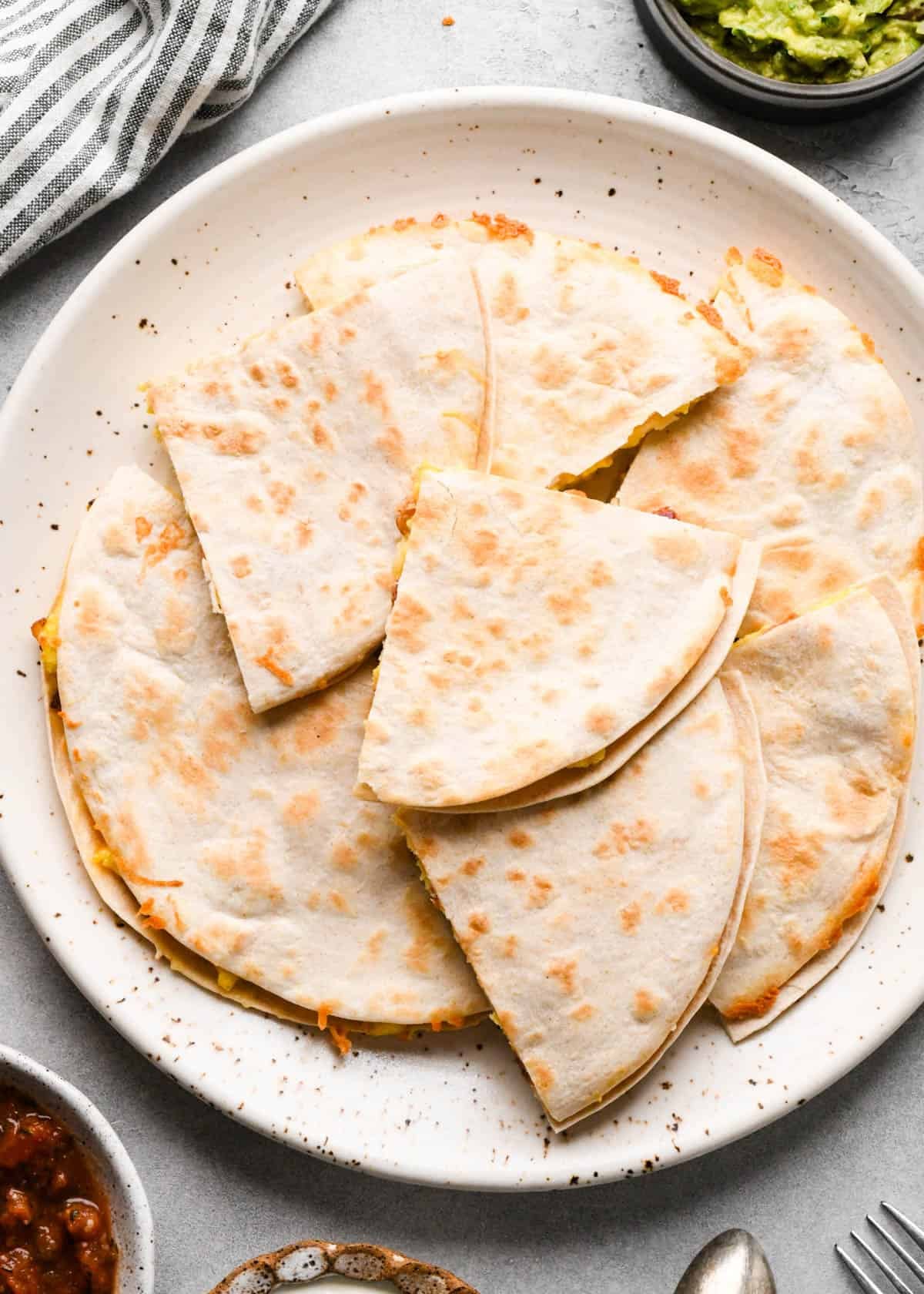 7 pieces of a breakfast quesadilla on a white plate cut into