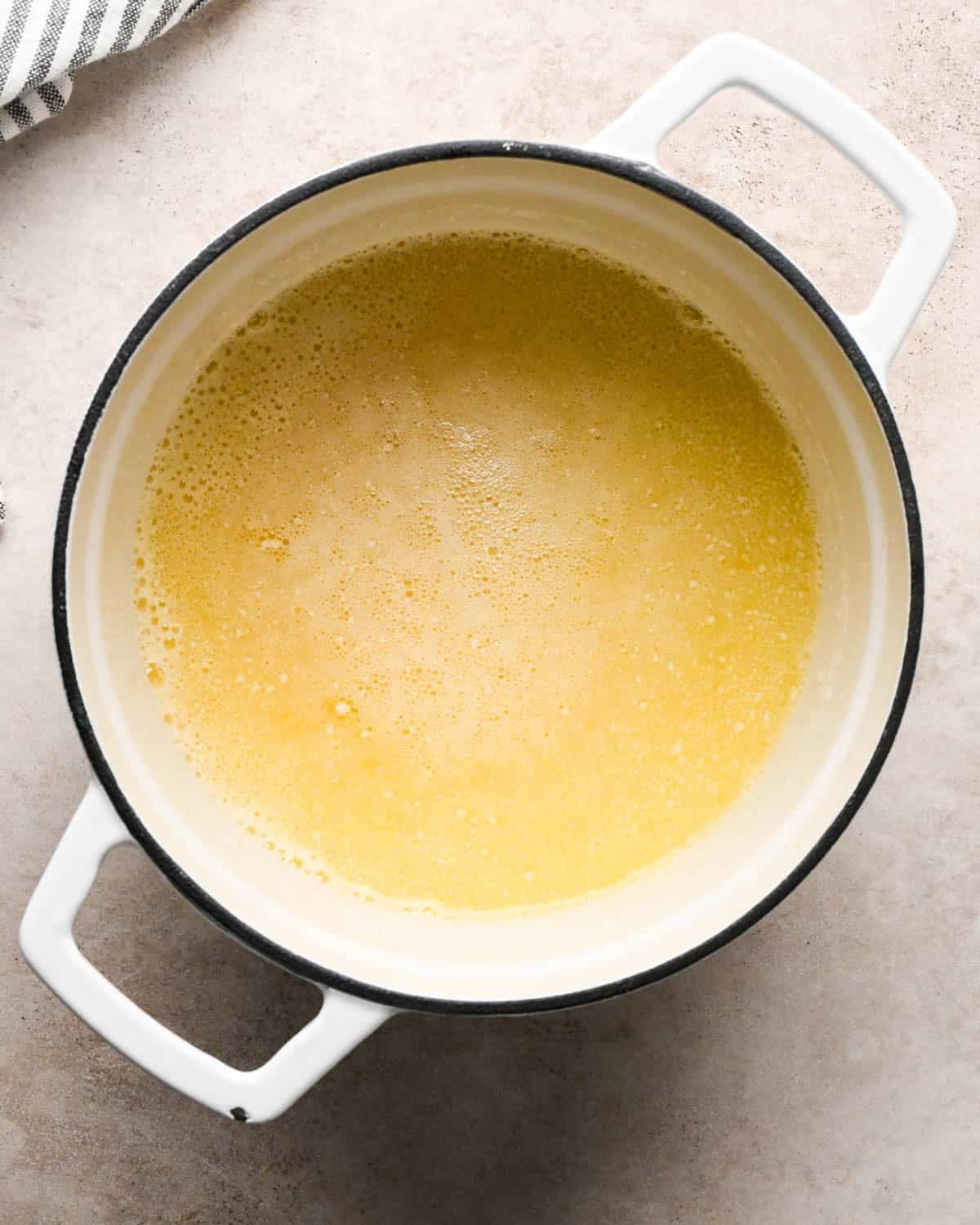 browning butter to make brown butter pumpkin cookies - melted butter in a white pot