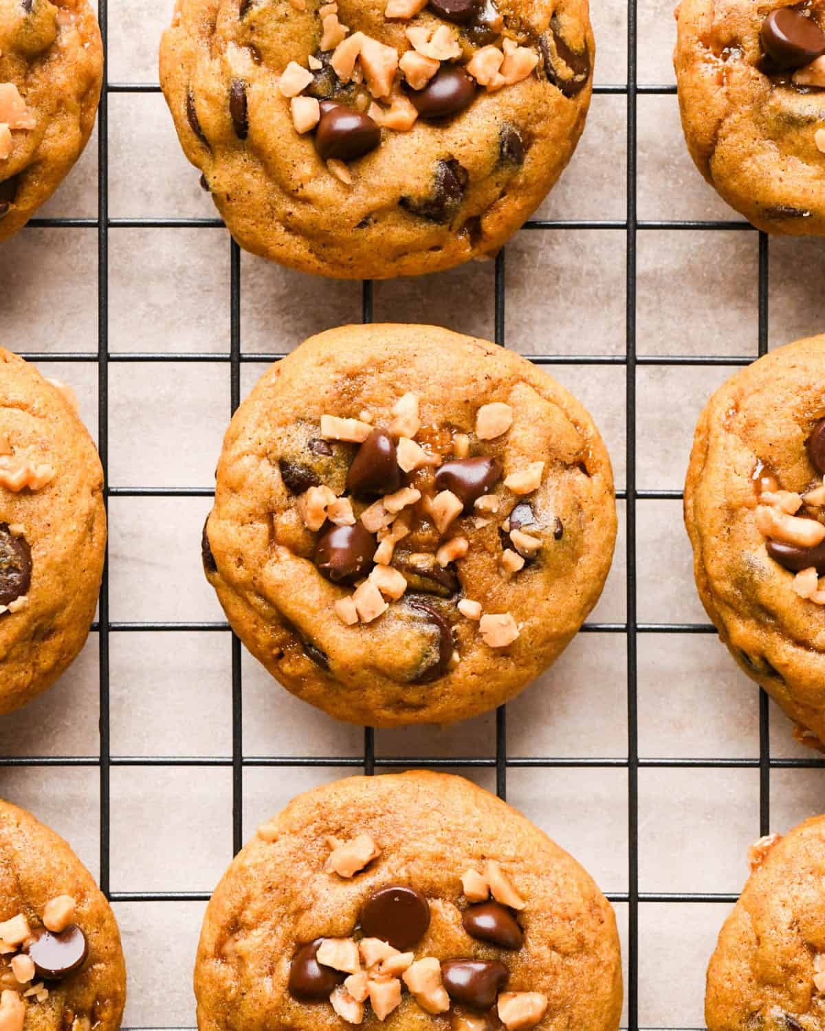 9 brown butter pumpkin cookies with chocolate chips and toffee bits on a wire cooling rack