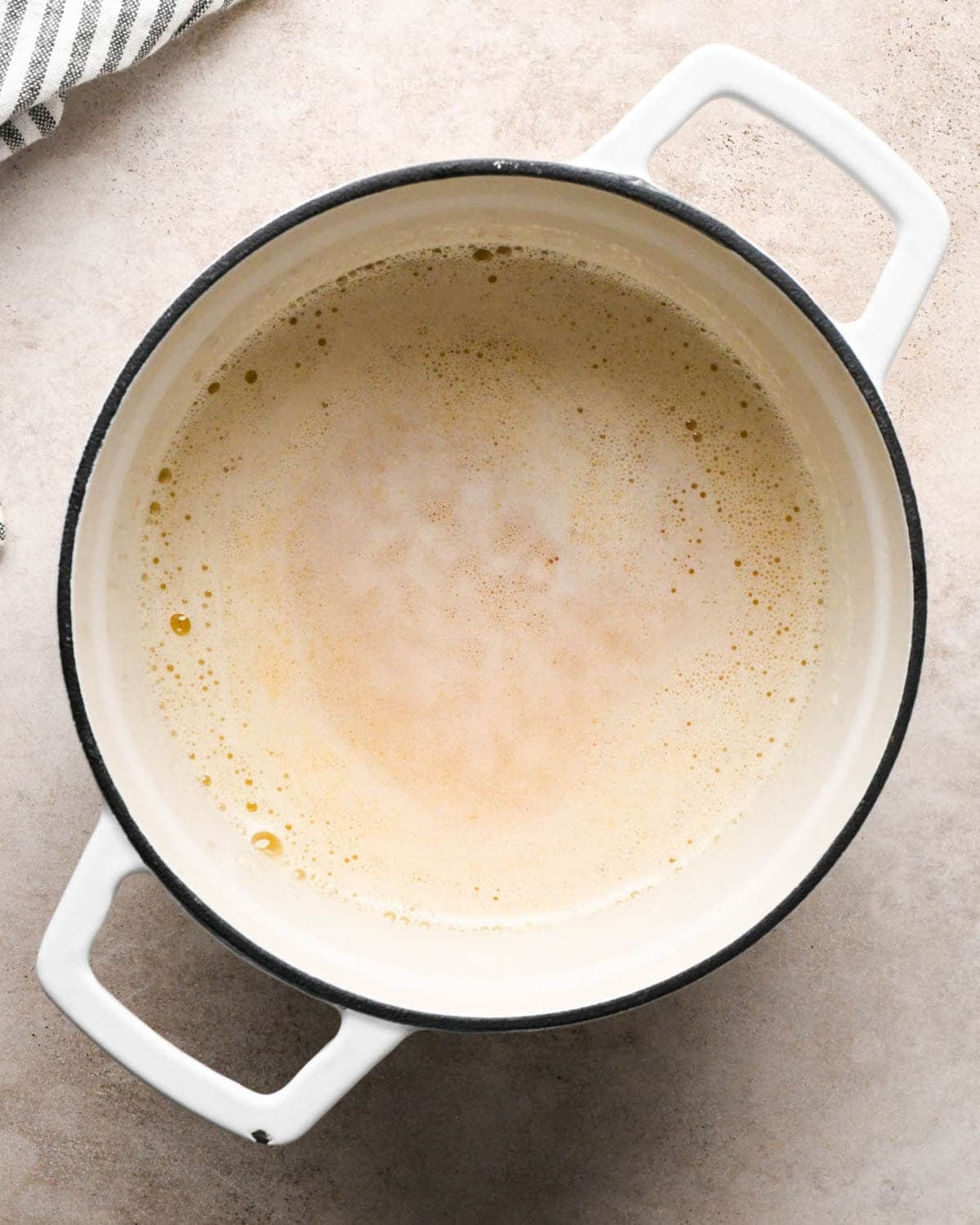 browning butter to make brown butter pumpkin cookies - butter foaming and turning brown in a white pot