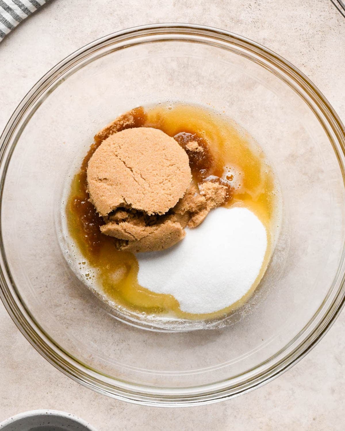 making brown butter pumpkin cookies - light brown sugar and white sugar in the brown butter in the glass mixing bowl before mixing
