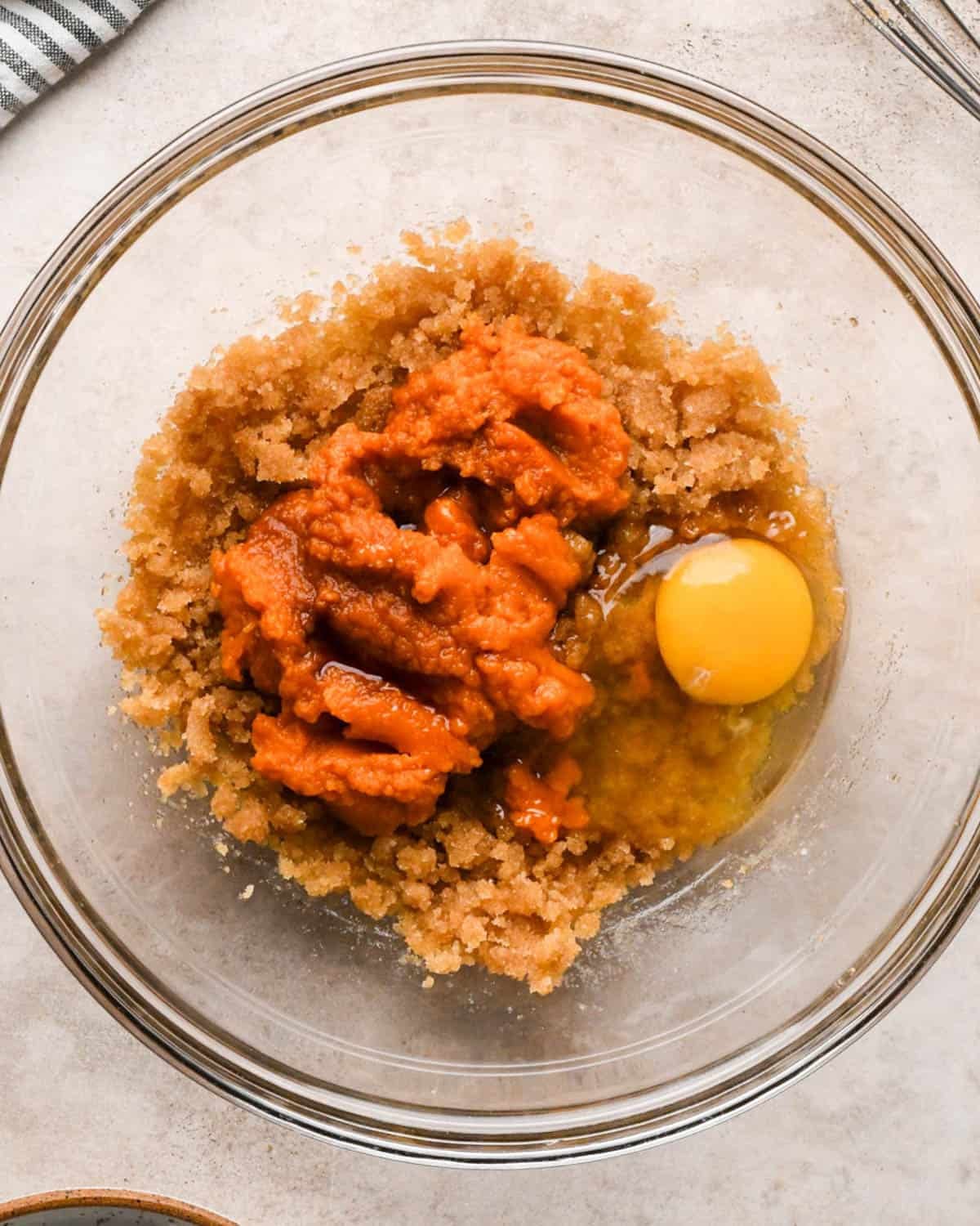 making brown butter pumpkin cookies -pumpkin, egg and vanilla added to the butter/sugar mixture in a glass mixing bowl before mixing