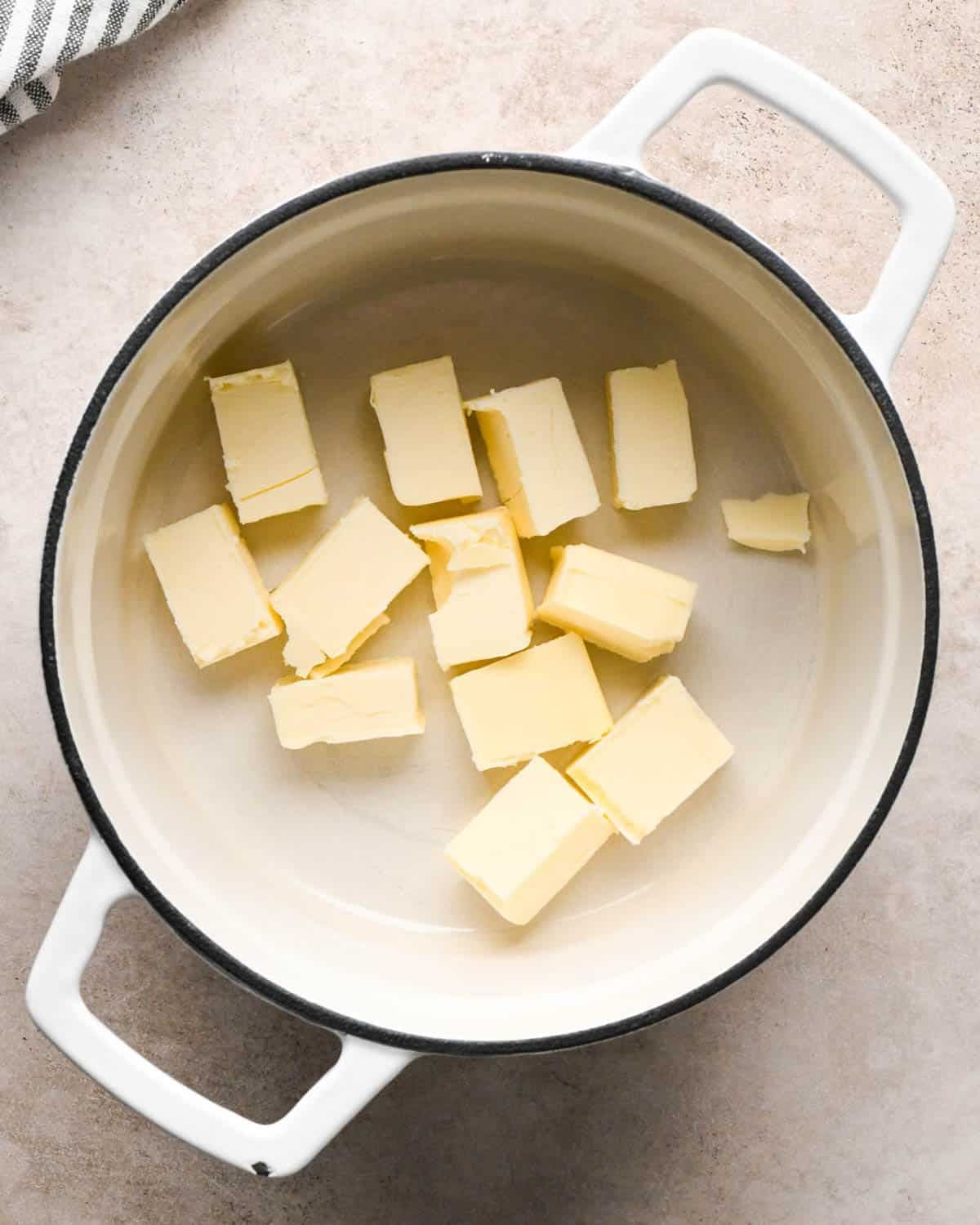 browning butter to make brown butter pumpkin cookies - cubed butter in a white pot