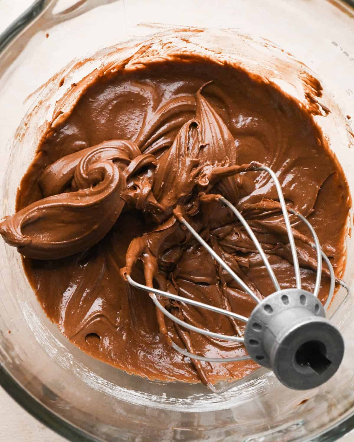 making brownie bites - final batter in a glass mixing bowl with the metal wire whisk attachment