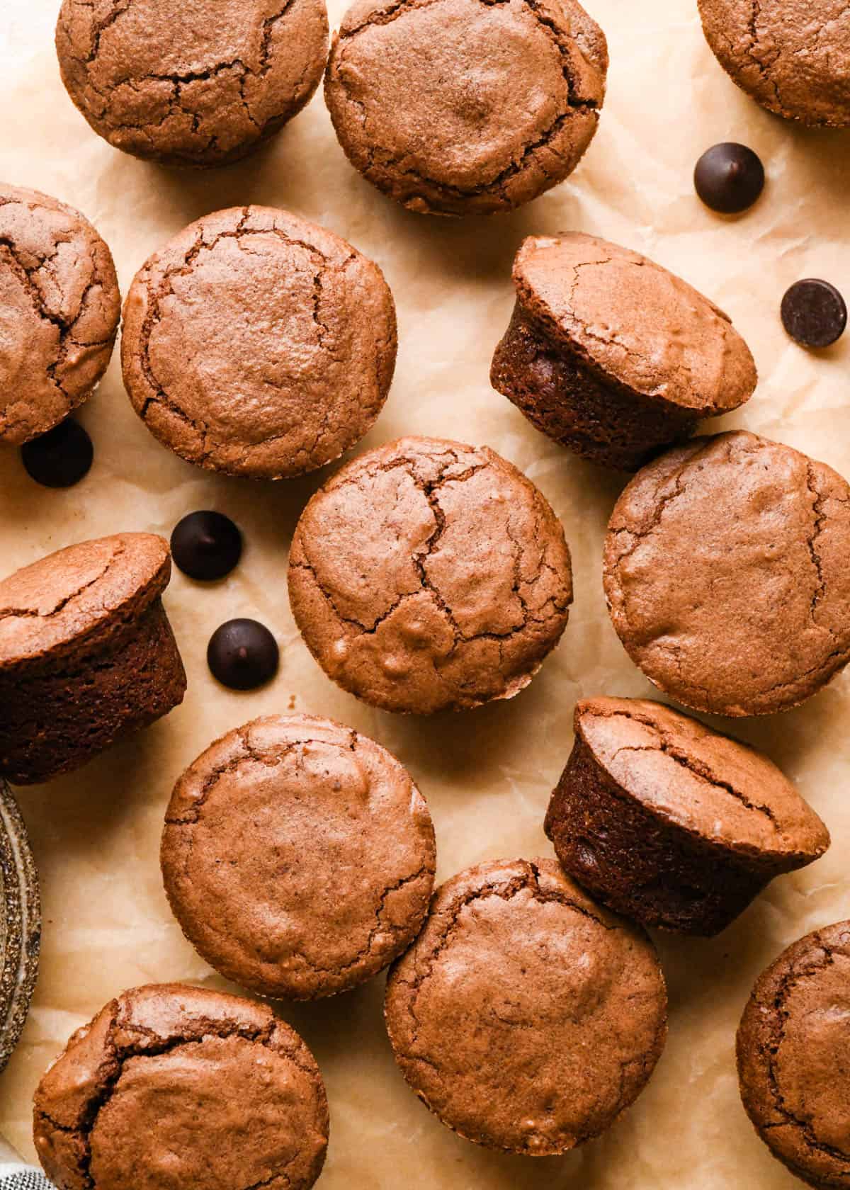 12 brownie bites on a parchment paper with chocolate chips