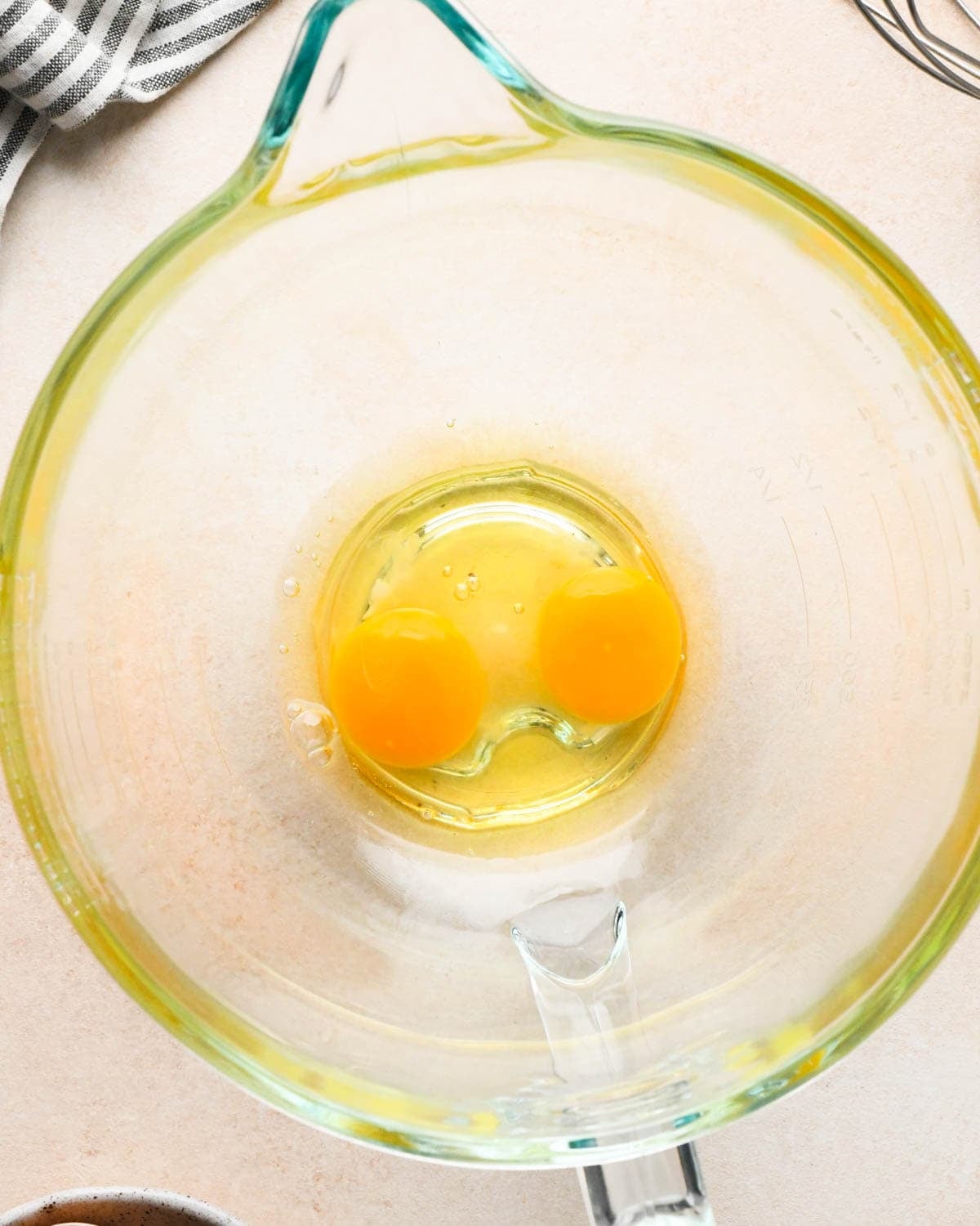 making brownie bites - two eggs in a glass mixing bowl