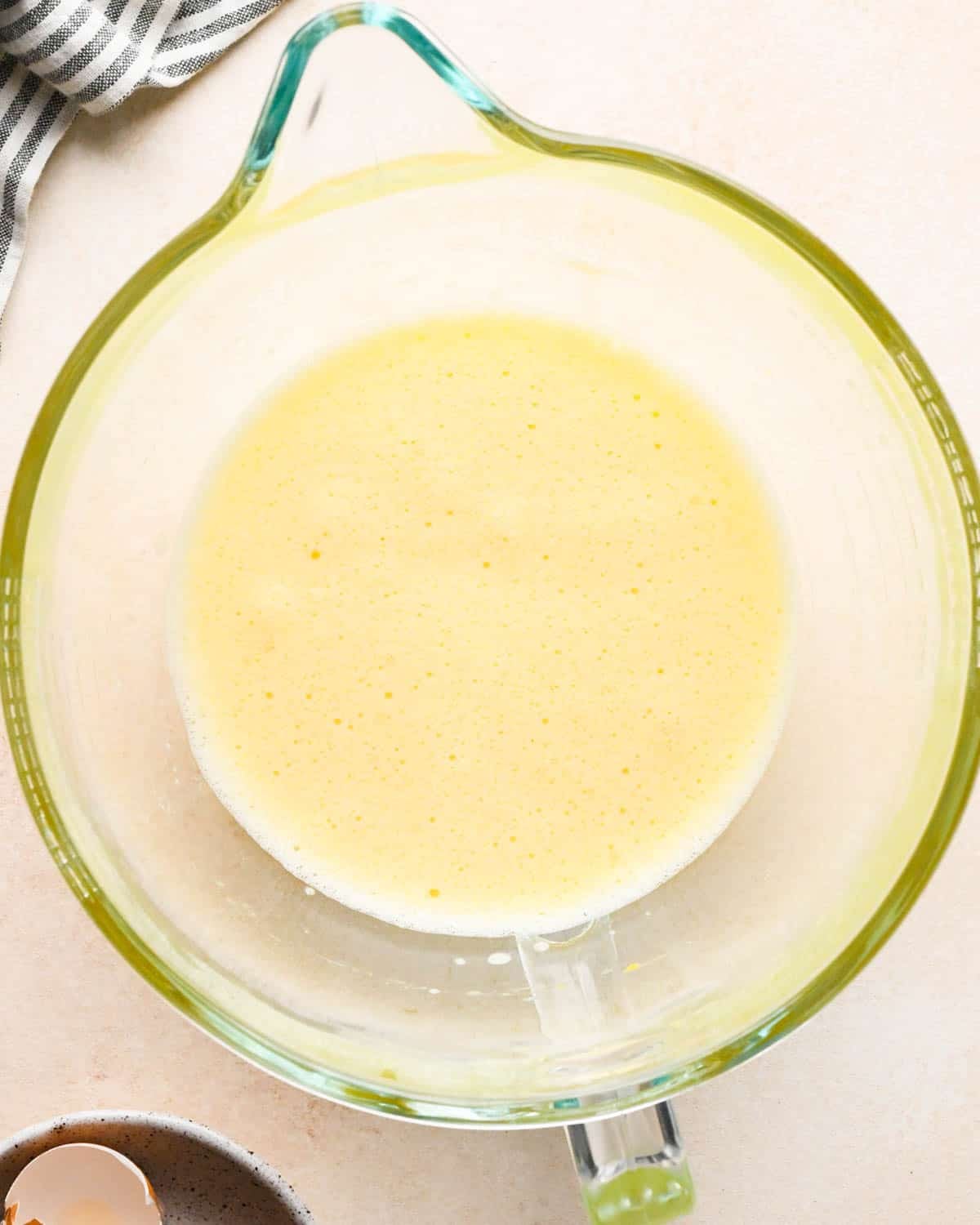 making brownie bites - beaten eggs in a glass mixing bowkl