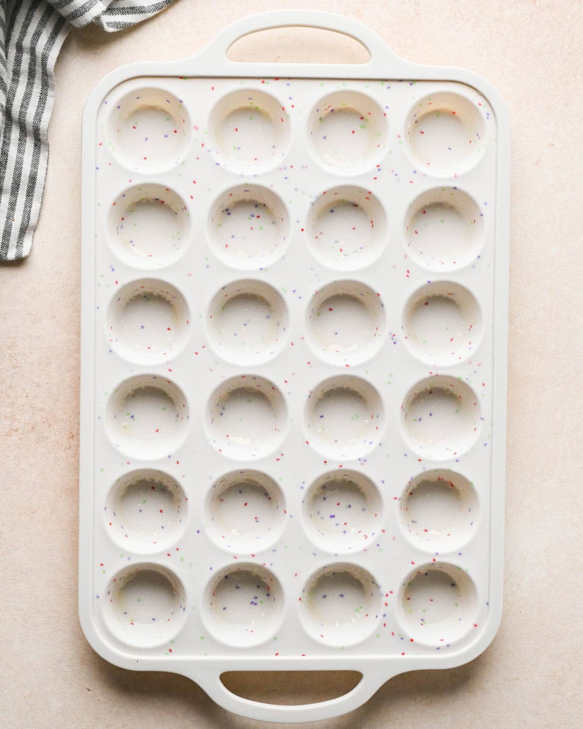 a white silicone mini muffin pan greased to make brownie bites