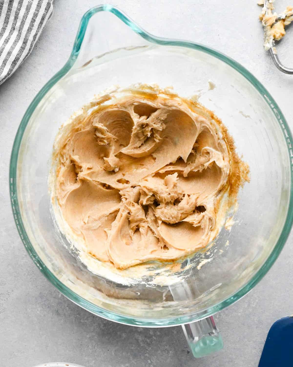 making caramel cream cheese apple dip - brown sugar added to the cream cheese in a glass mixing bowl after beating