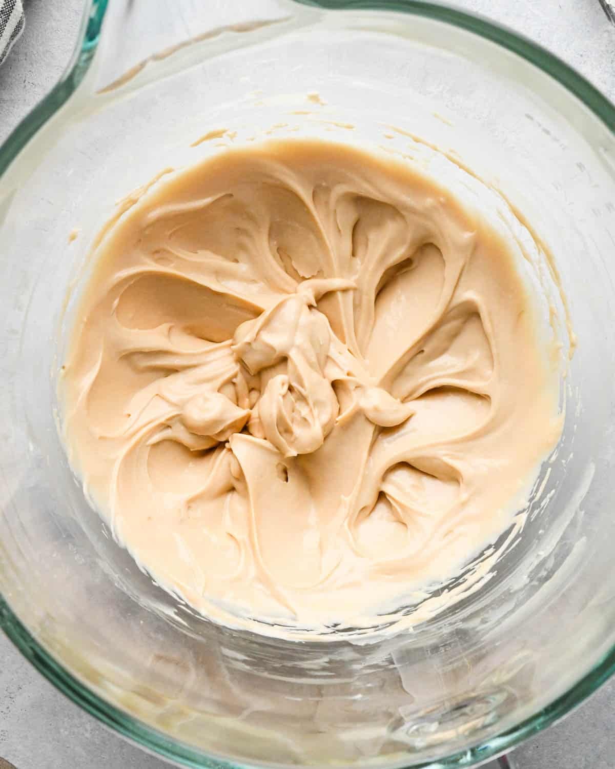 cream cheese apple caramel dip in a glass mixing bowl after beating
