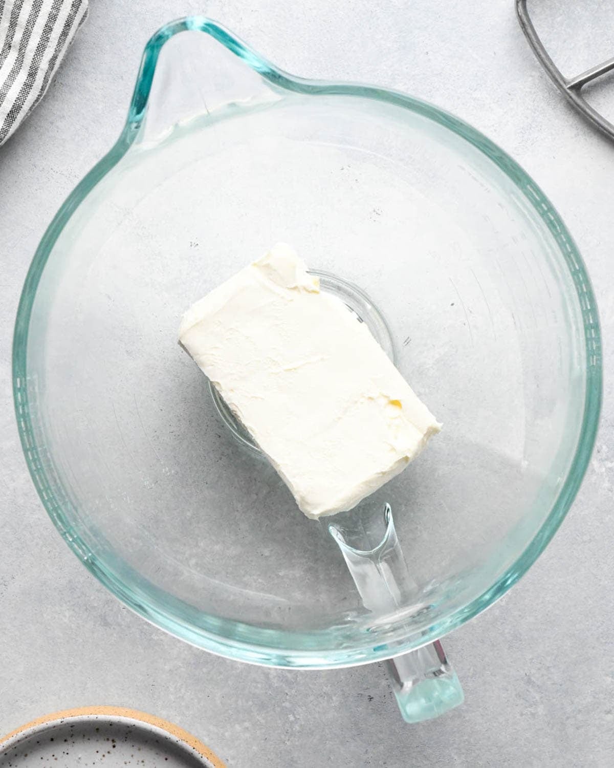 making caramel cream cheese apple dip - a block of cream cheese in a glass mixing bowl