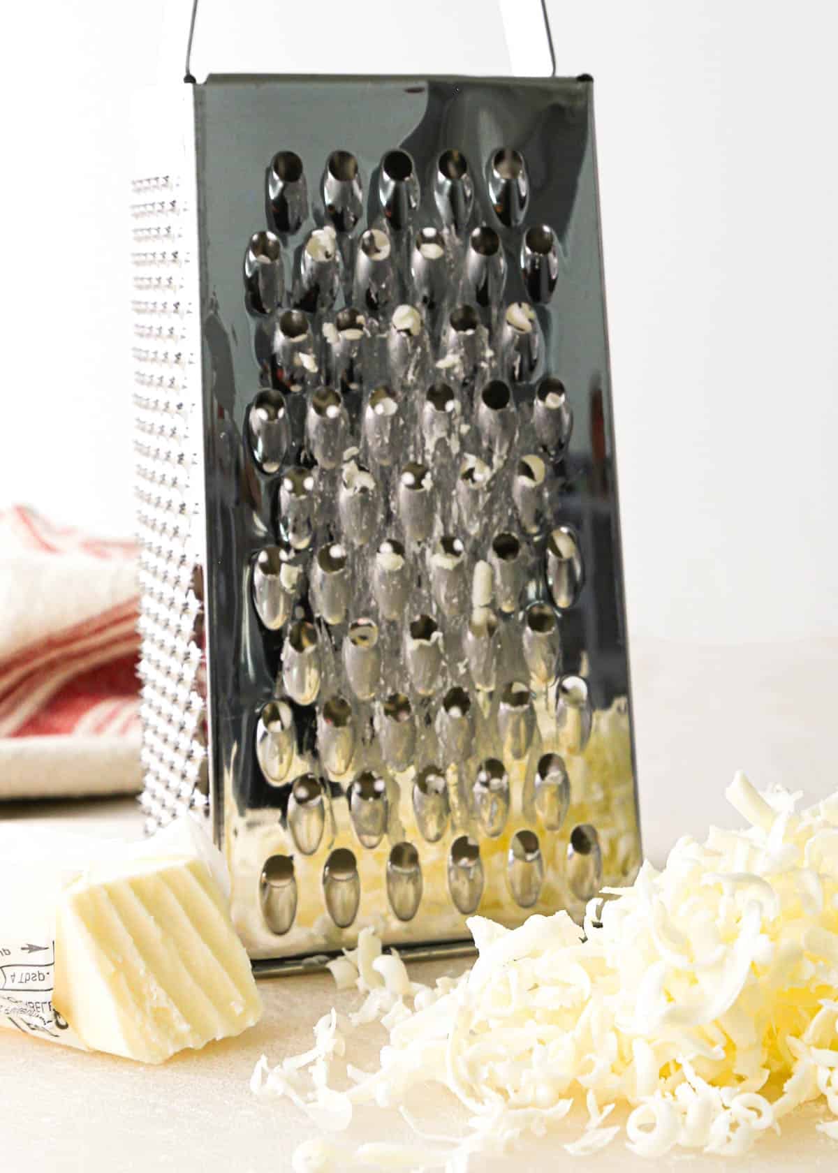 making apple scones - grating frozen butter with a metal box grater