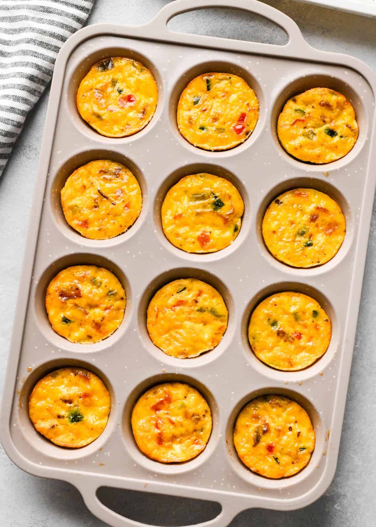 cottage cheese egg bites mixture in a tan/gray silicone muffin pan after baking