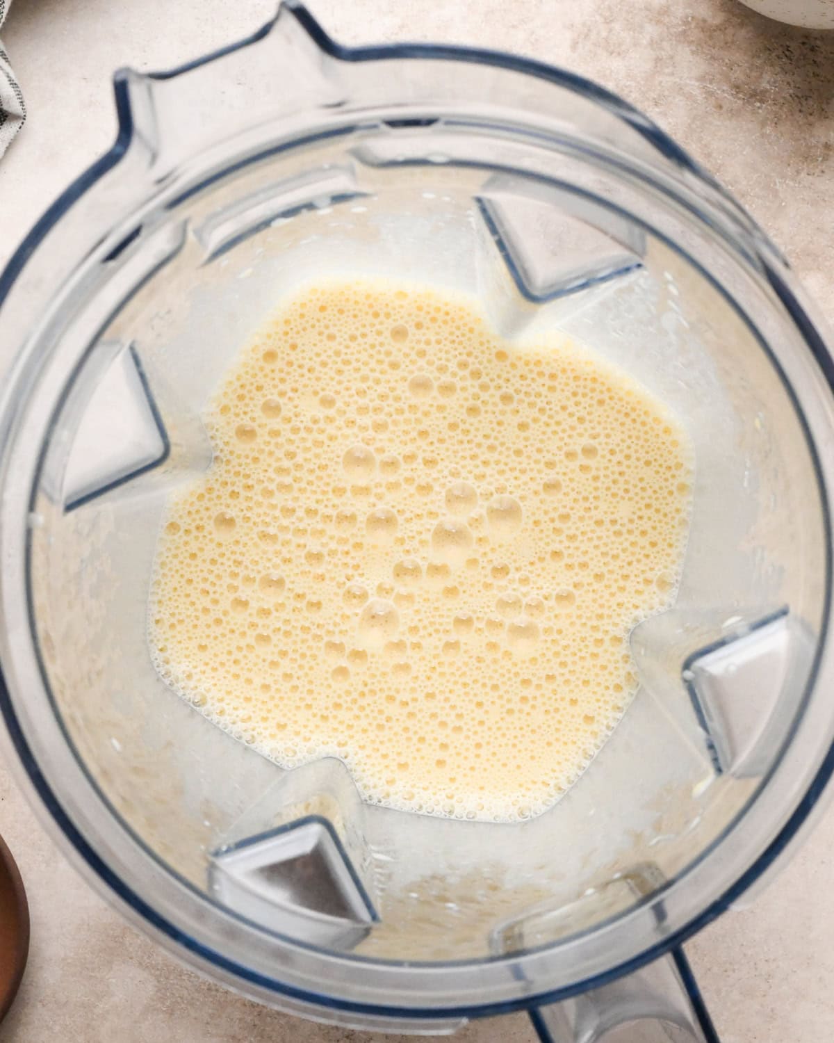 Making a Dutch baby: overhead view of dry ingredients added to a blender with the beaten eggs and blended together.