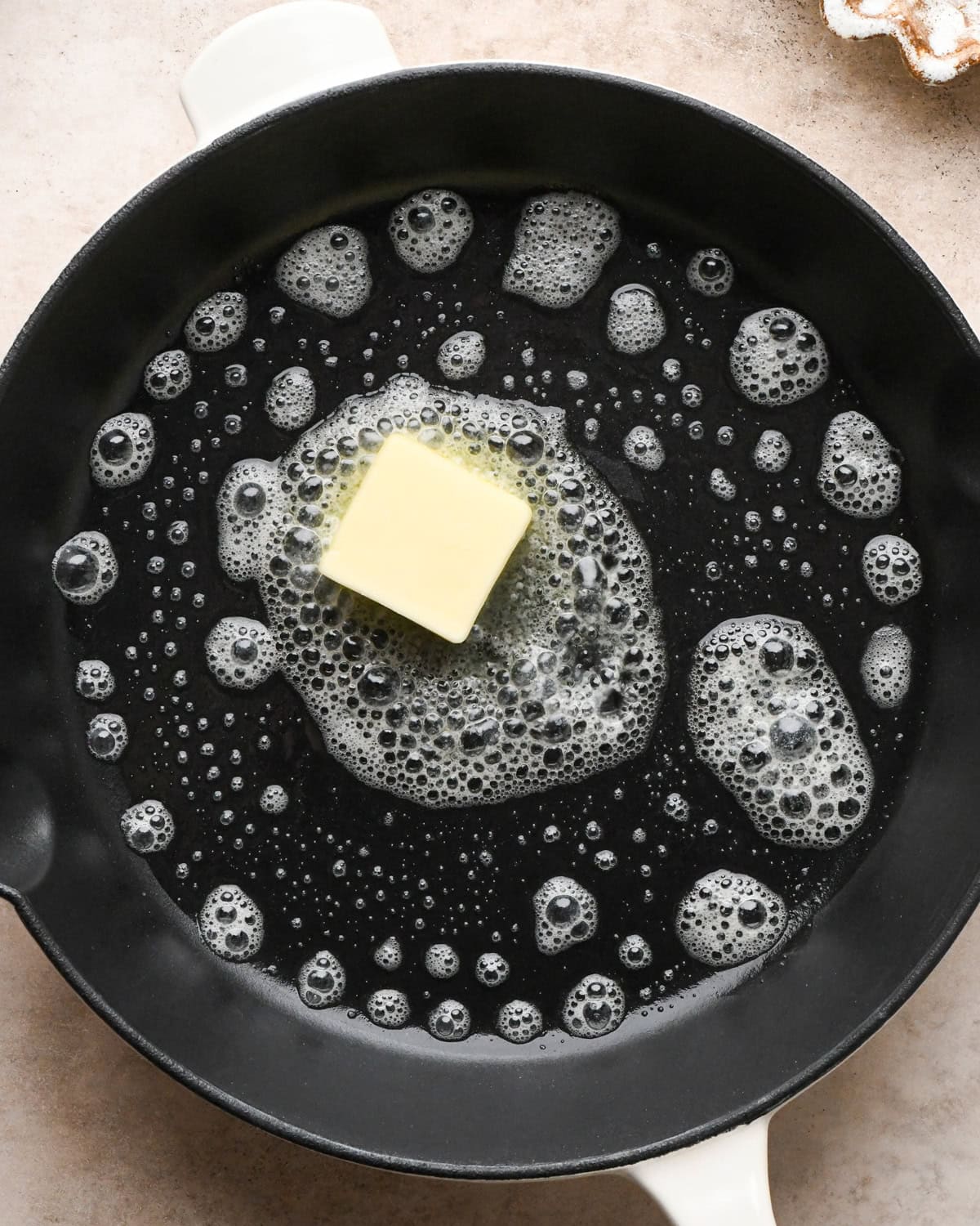 Making a Dutch baby: overhead view of butter being melted in a cast-iron skillet.