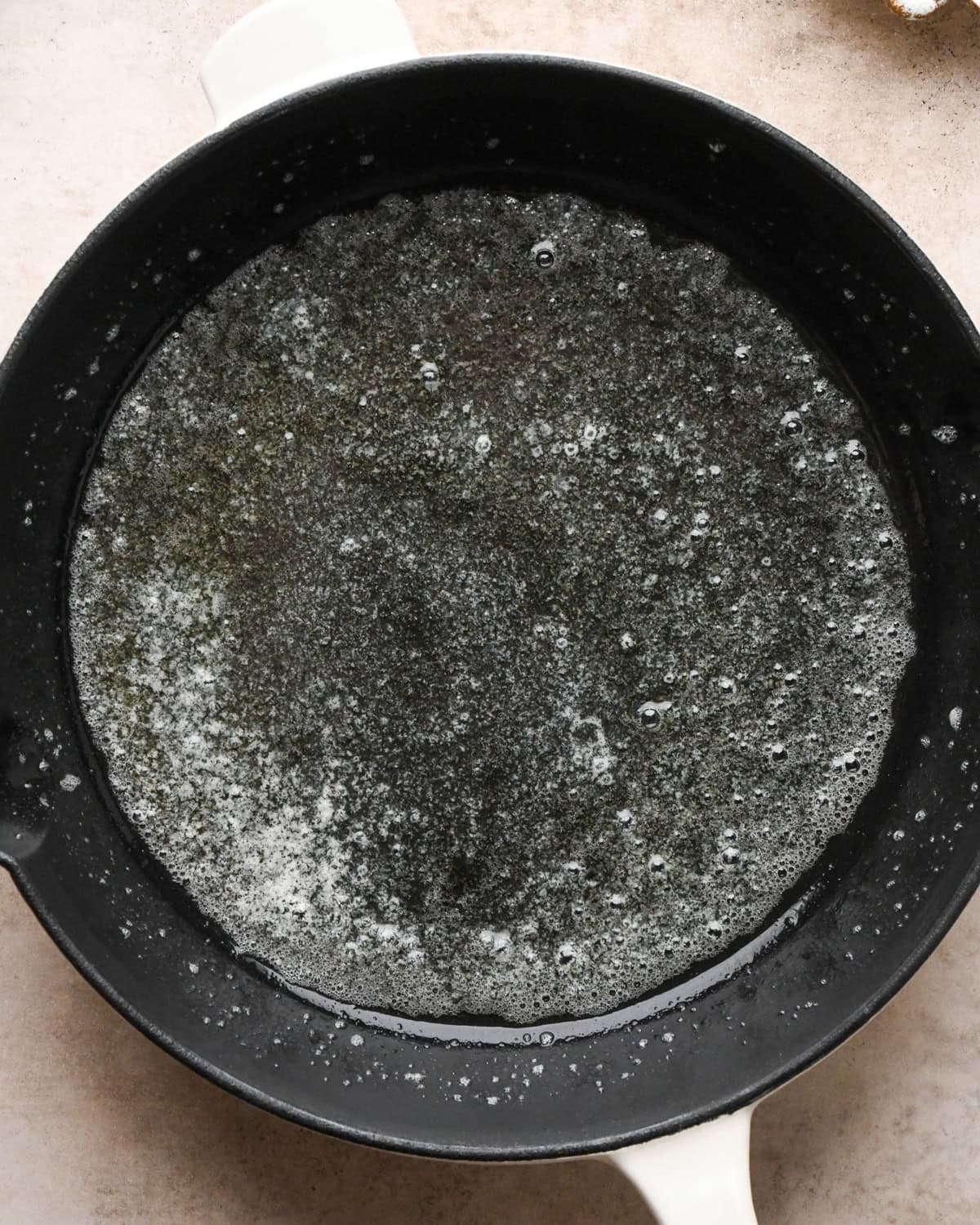 Making a Dutch baby: overhead view of butter melted in a cast-iron skillet.