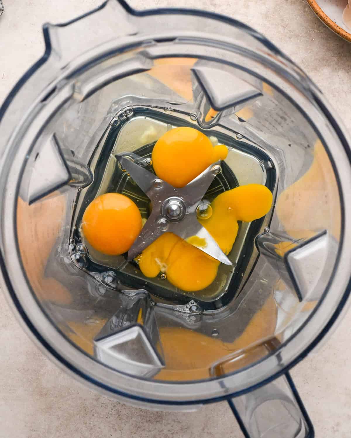 Making a Dutch baby: overhead view of eggs cracked into a blender.