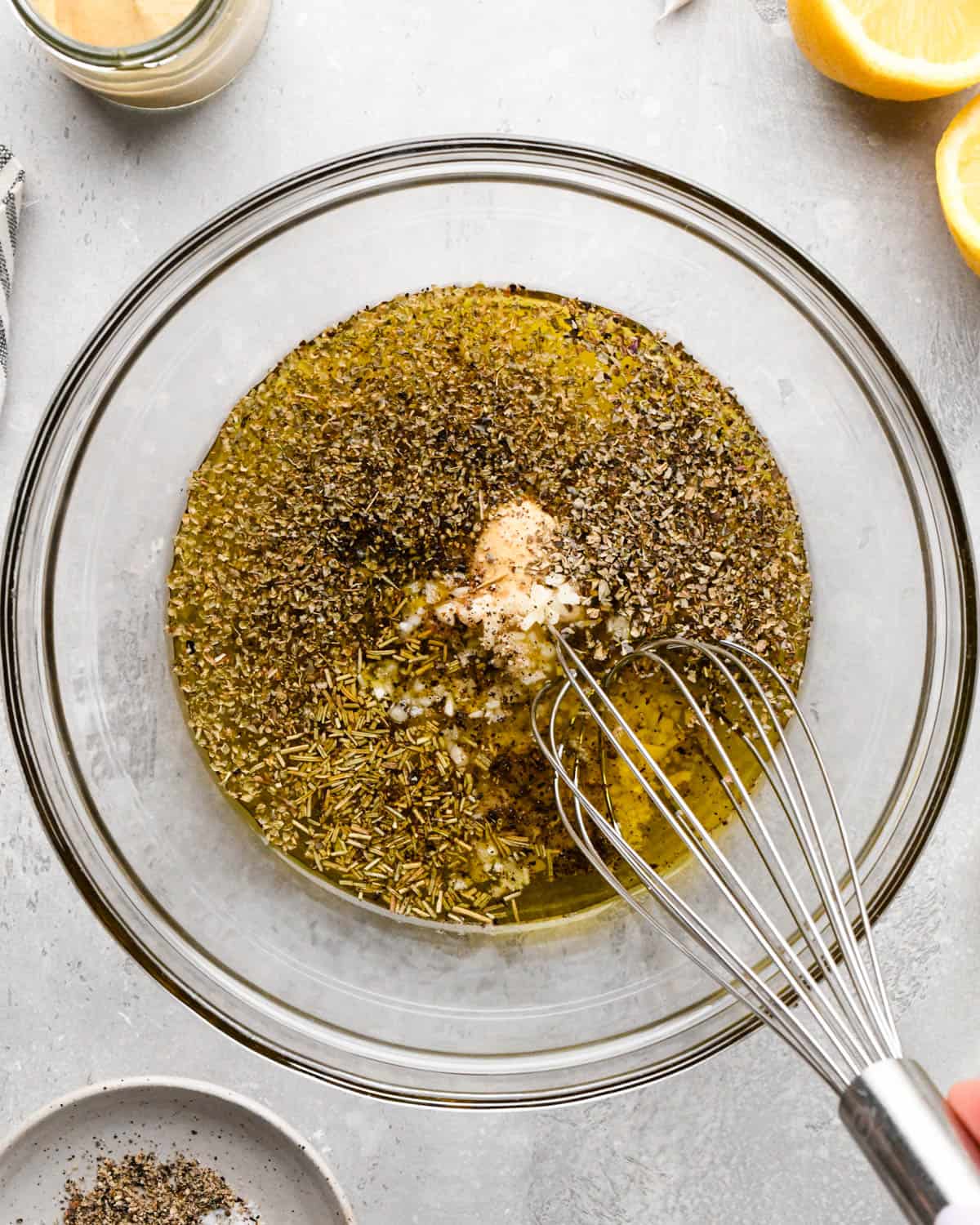 all the ingredients for this italian dressing recipe in a glass bowl with a whisk before mixing