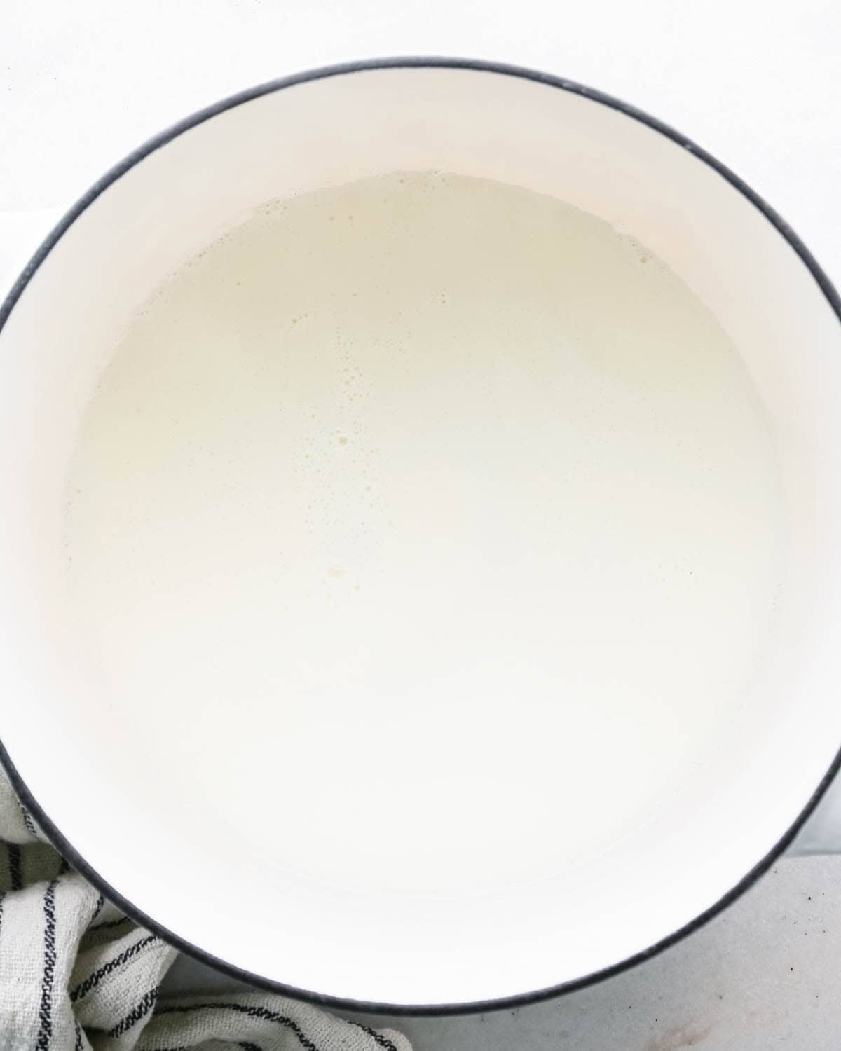 making chocolate glaze - heavy cream in a white pot