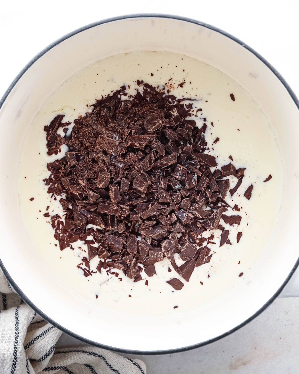 making chocolate glaze - chocolate, corn syrup and salt added to the heavy cream in a white pot