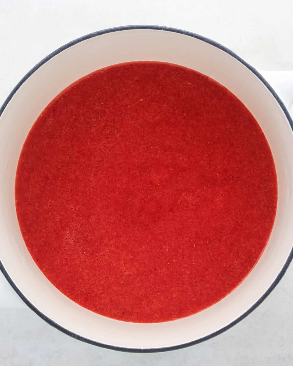 making strawberry cake - strawberry puree in a white saucepan