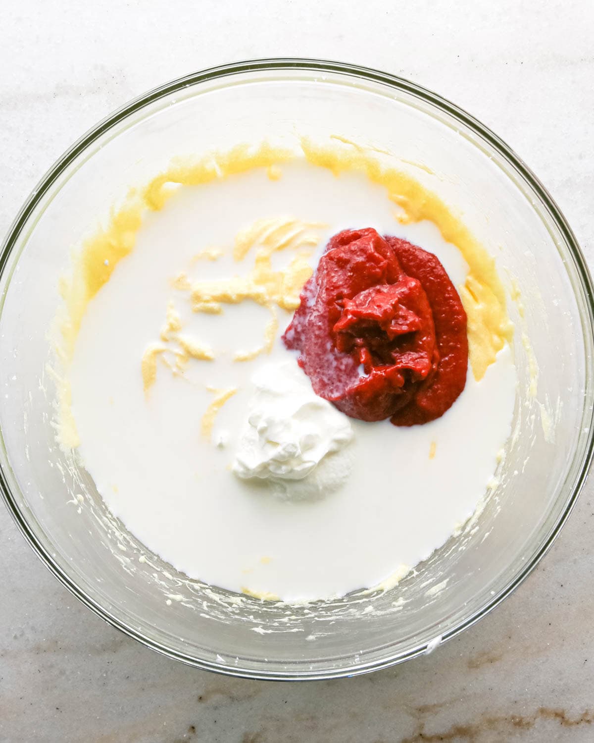 making strawberry cake - milk, sour cream and strawberry reduction added to the butter mixture