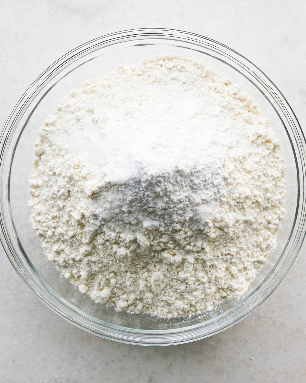 making strawberry cake - flour, salt, baking soda and baking powder in a glass bowl before stirring.