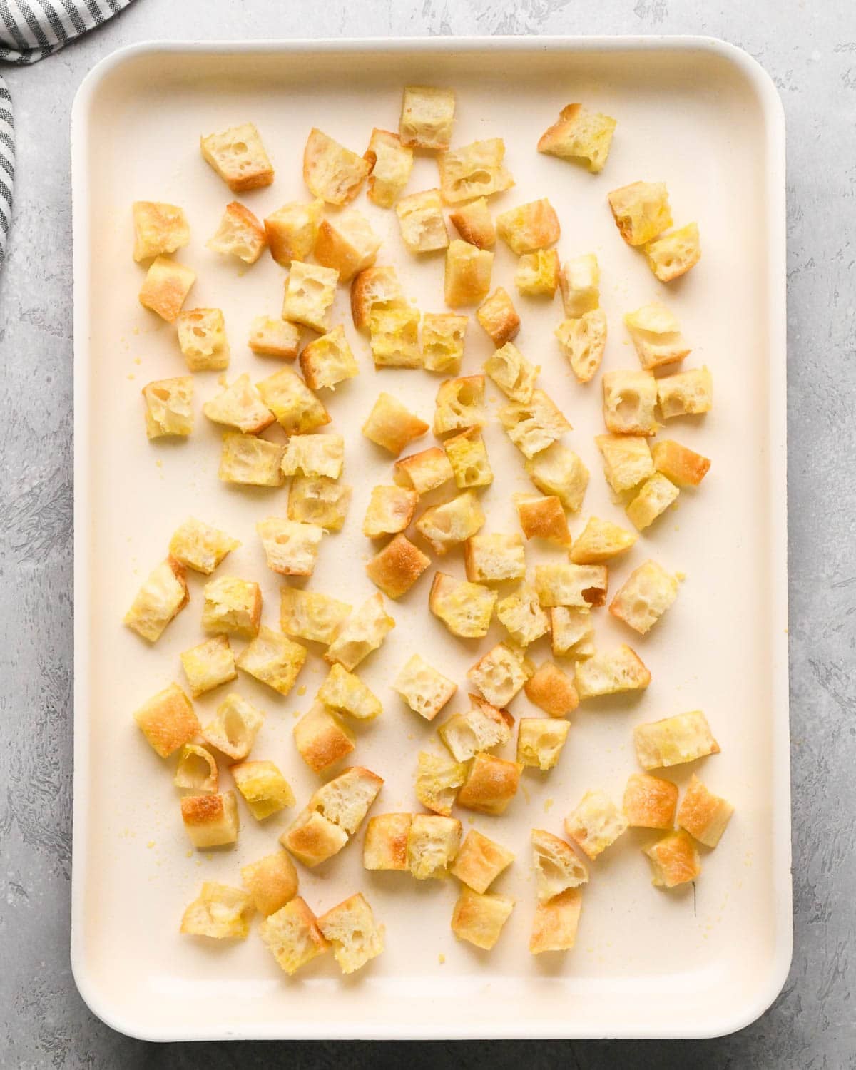 making croutons for Italian salad - bread spread out on a baking sheet before baking