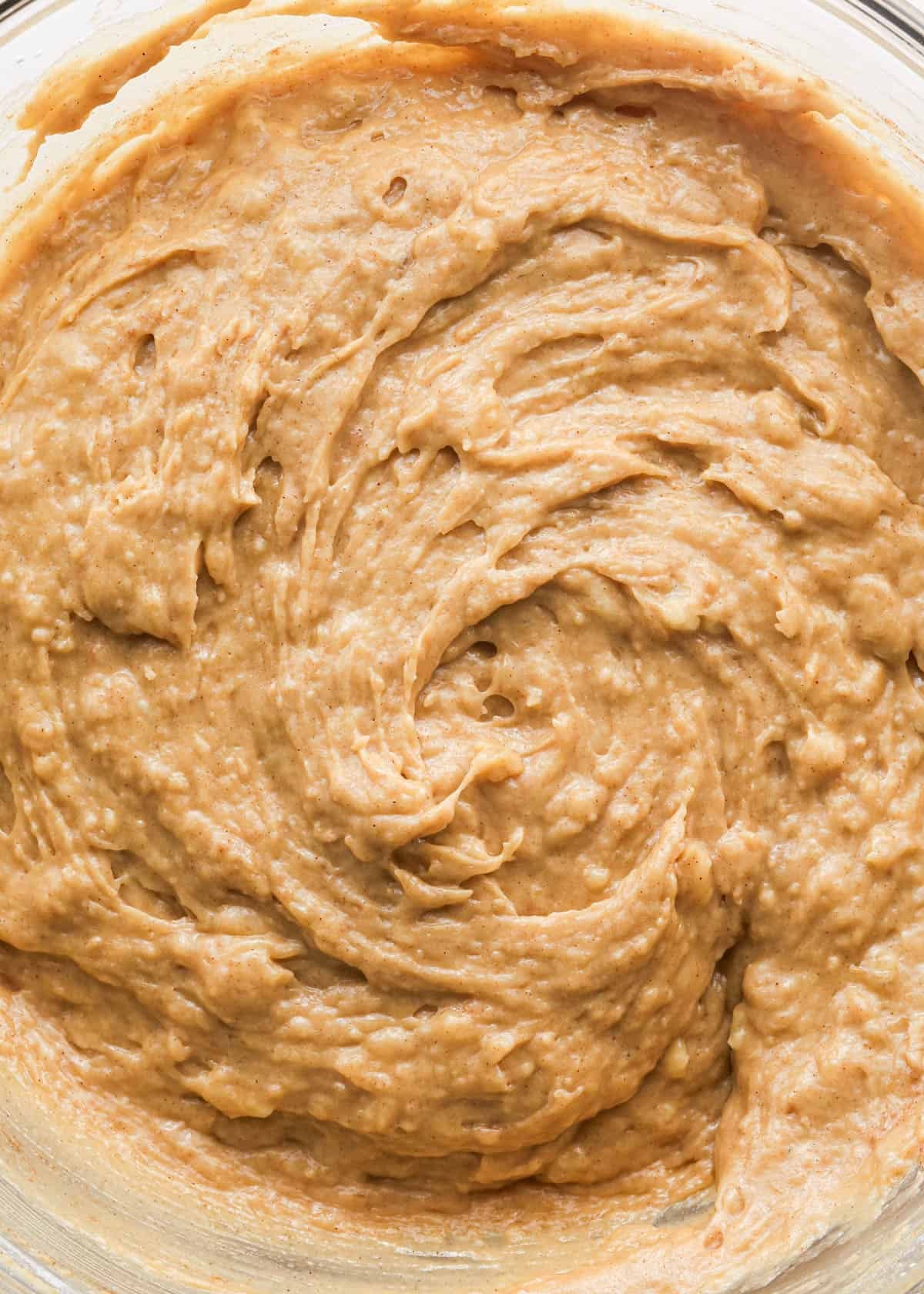 making peanut butter banana muffins - final mixed batter in a glass bowl.
