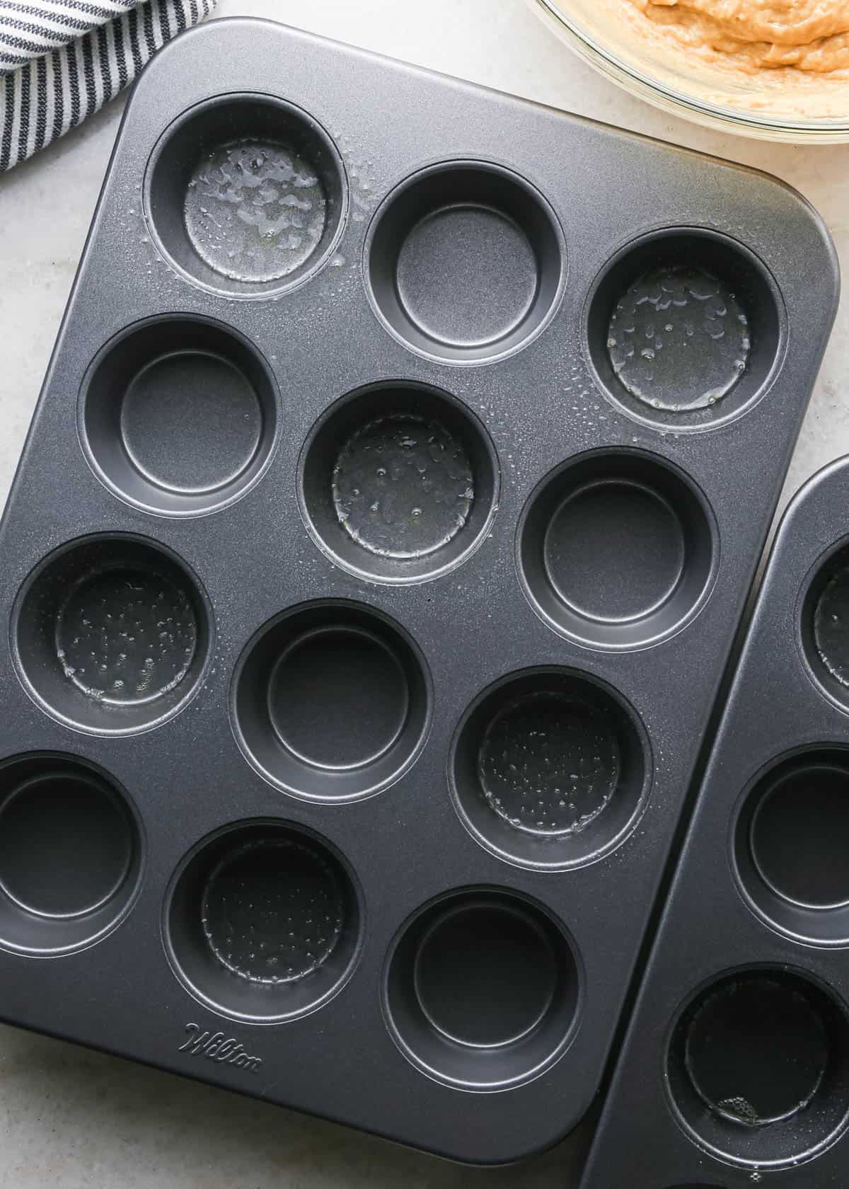 making peanut butter banana muffins - a muffin tin with 6 wells greased