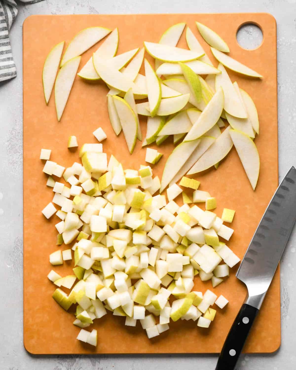 how to make pear salad - diced and sliced pears on a cutting board with a knife