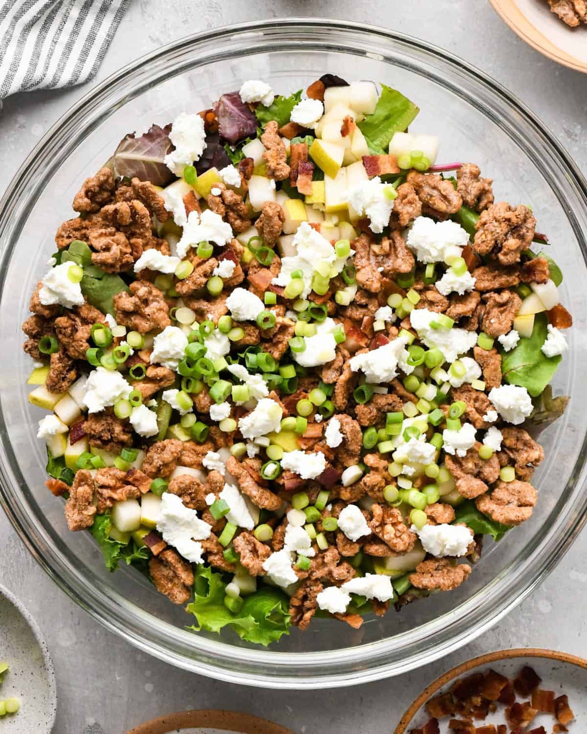 assembling a pear salad - all the ingredients in a glass serving bowl before mixing