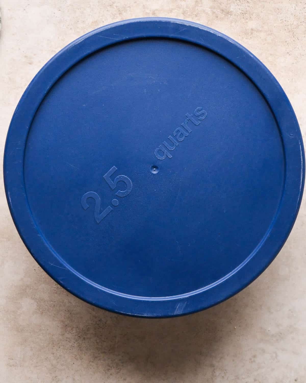 vegan oatmeal cookies dough in a glass bowl with a blue lid to chill in the refrigerator