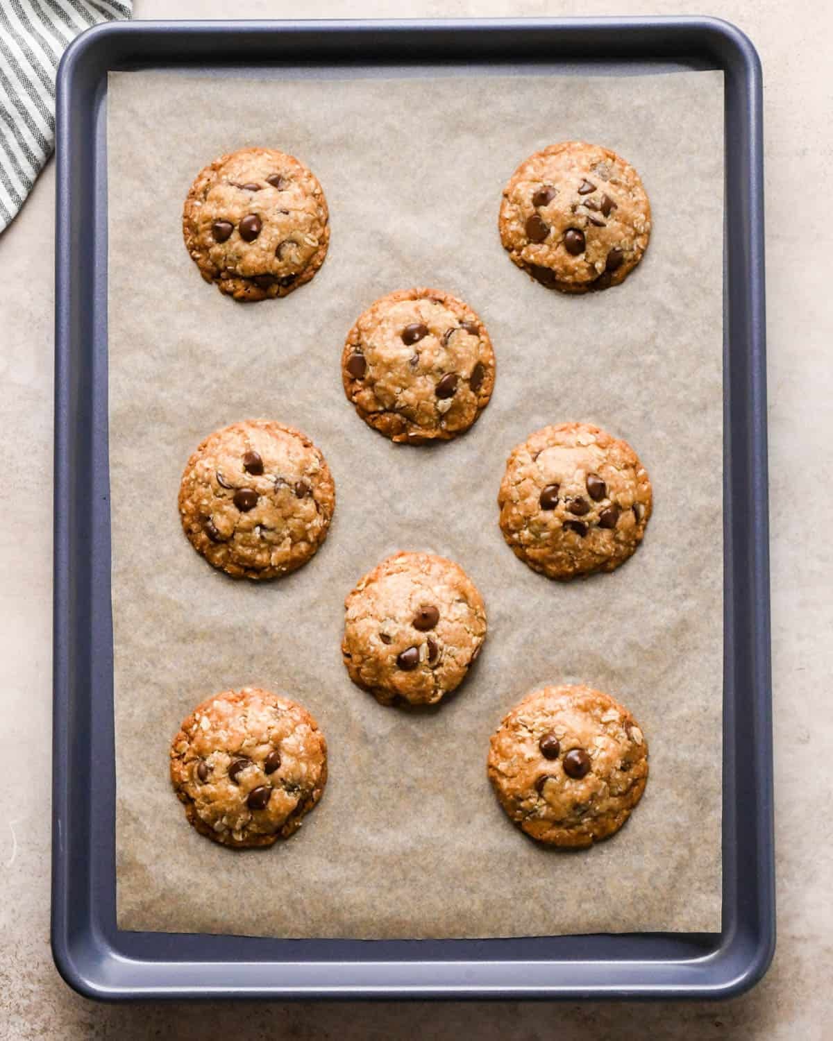 8 baked vegan oatmeal cookies on a baking sheet lined with parchment paper