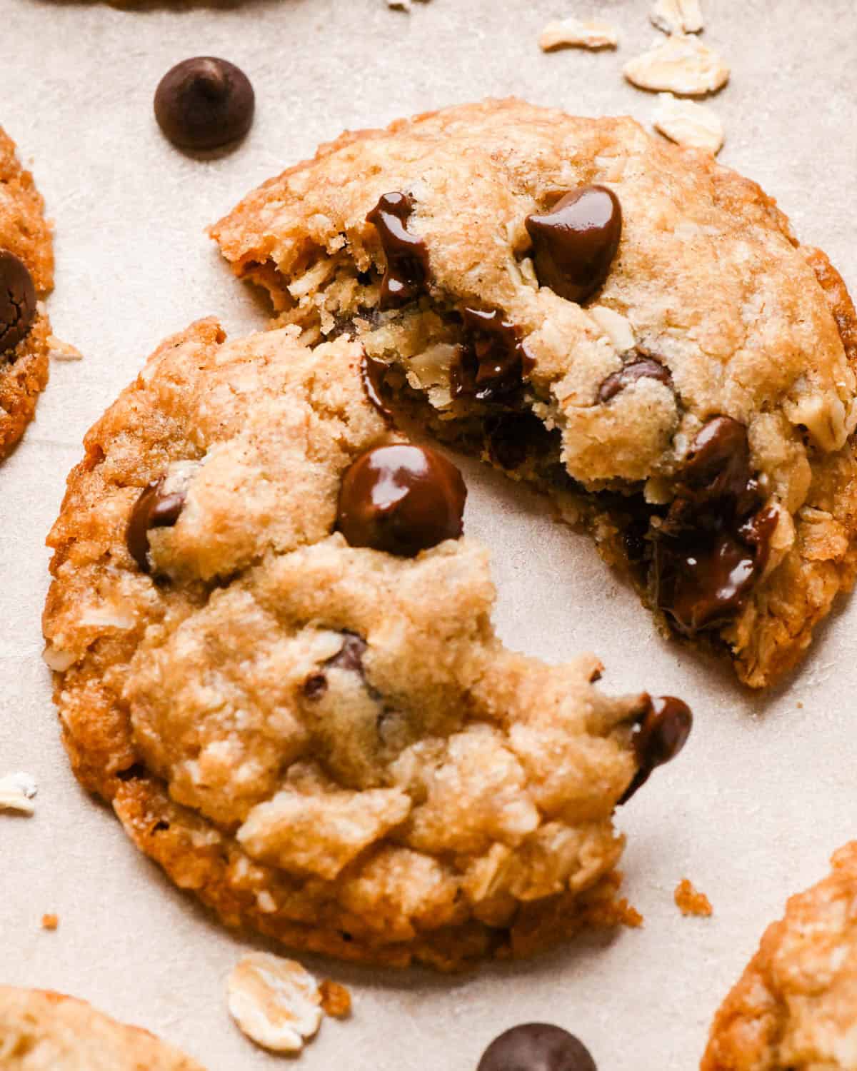 a vegan oatmeal cookie cut in half and pulled apart so the melty chocolate chips and gooey inside is visible