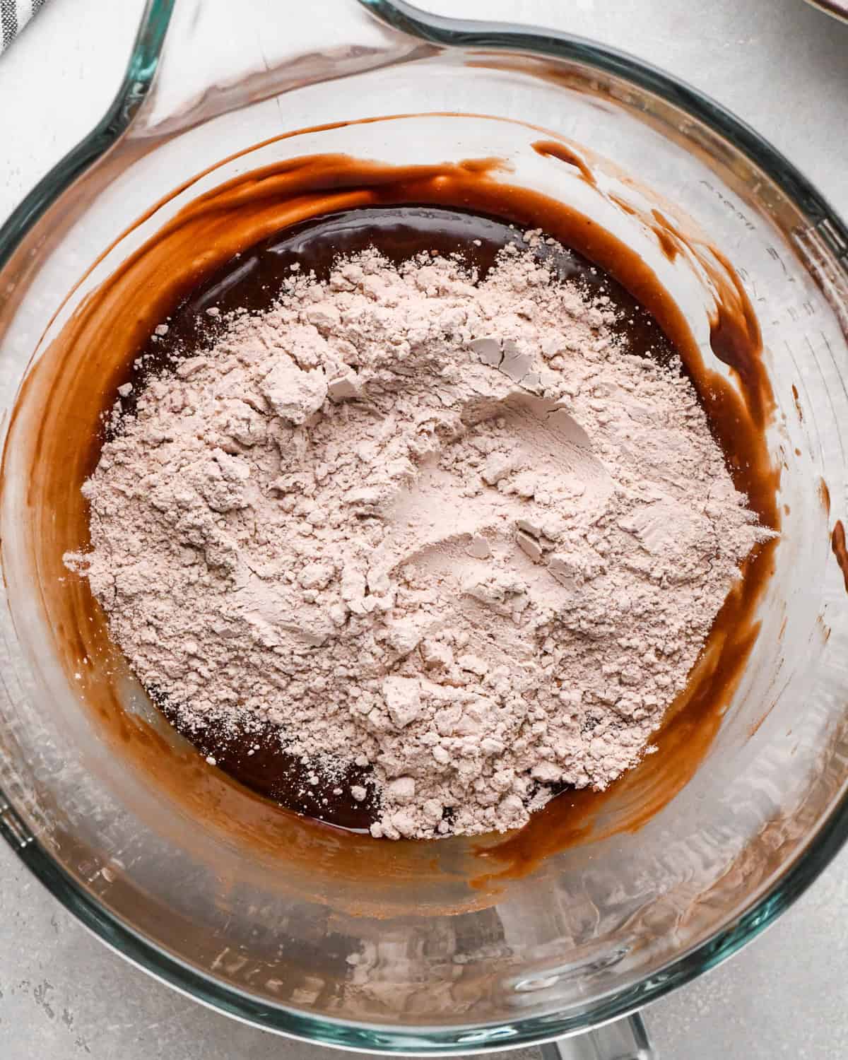 Making gluten-free brownies: overhead photo of final dry ingredients being added to brownie batter in a large mixing bowl.