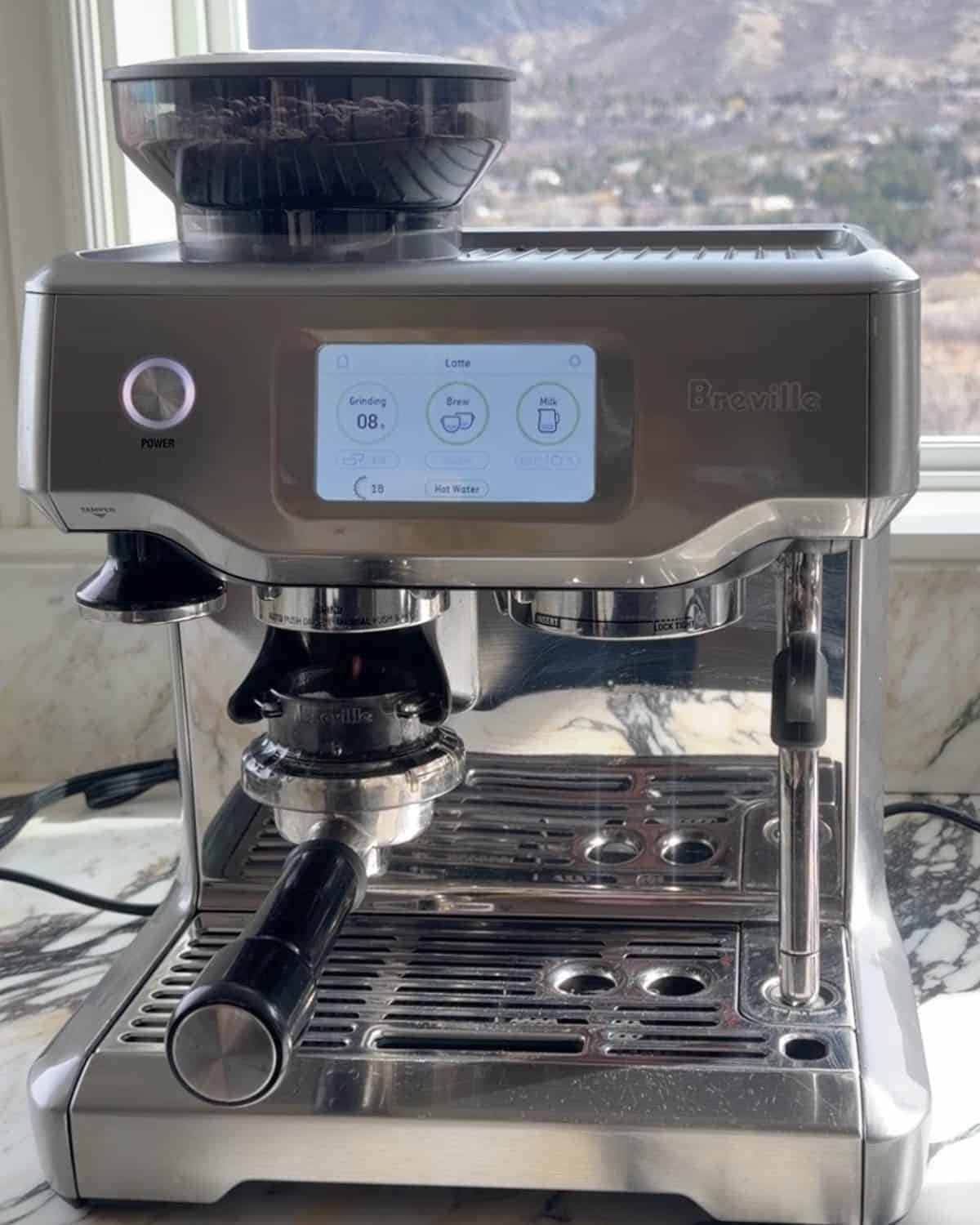 how to make a latte - beans being ground in an espresso machine