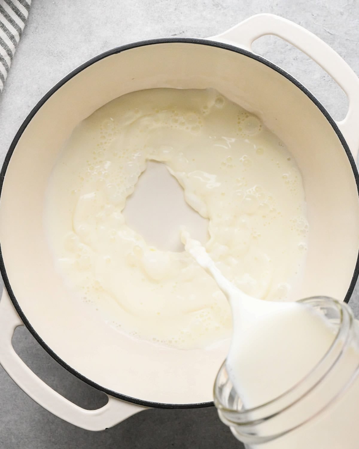 Making rice pudding: overhead photo of whole milk being poured into a large white pot.