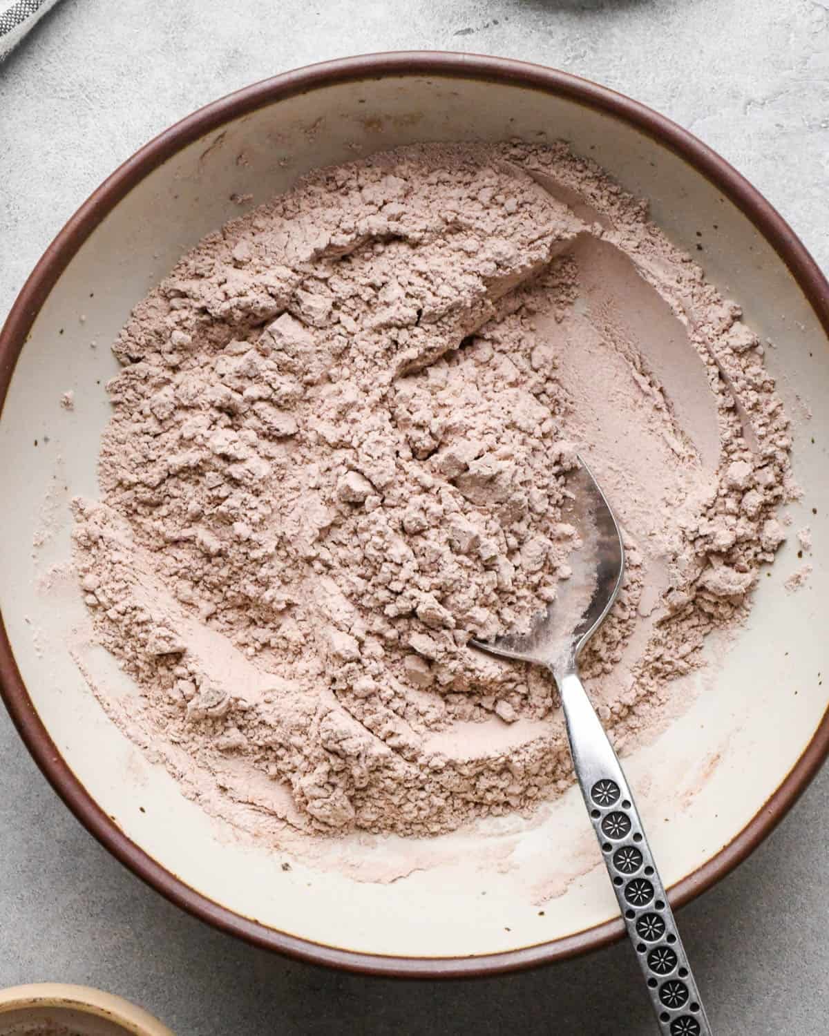 Making buckeye brownies: overhead photo of flour, salt, and cocoa powder in a small bowl being mixed together with a spoon.