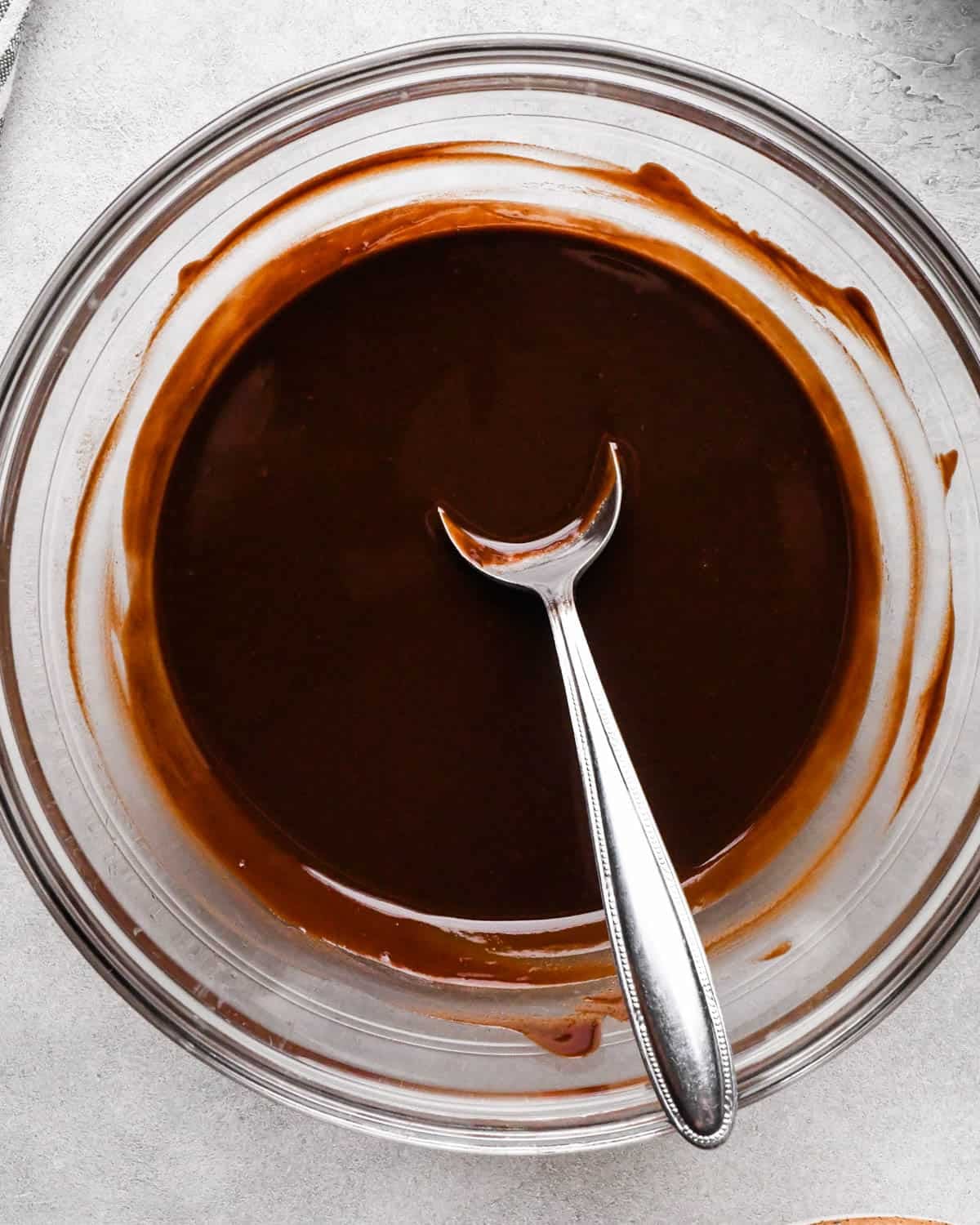 Making buckeye brownies: overhead photo of butter and chocolate chips melted in a small bowl and being stirred with a spoon.
