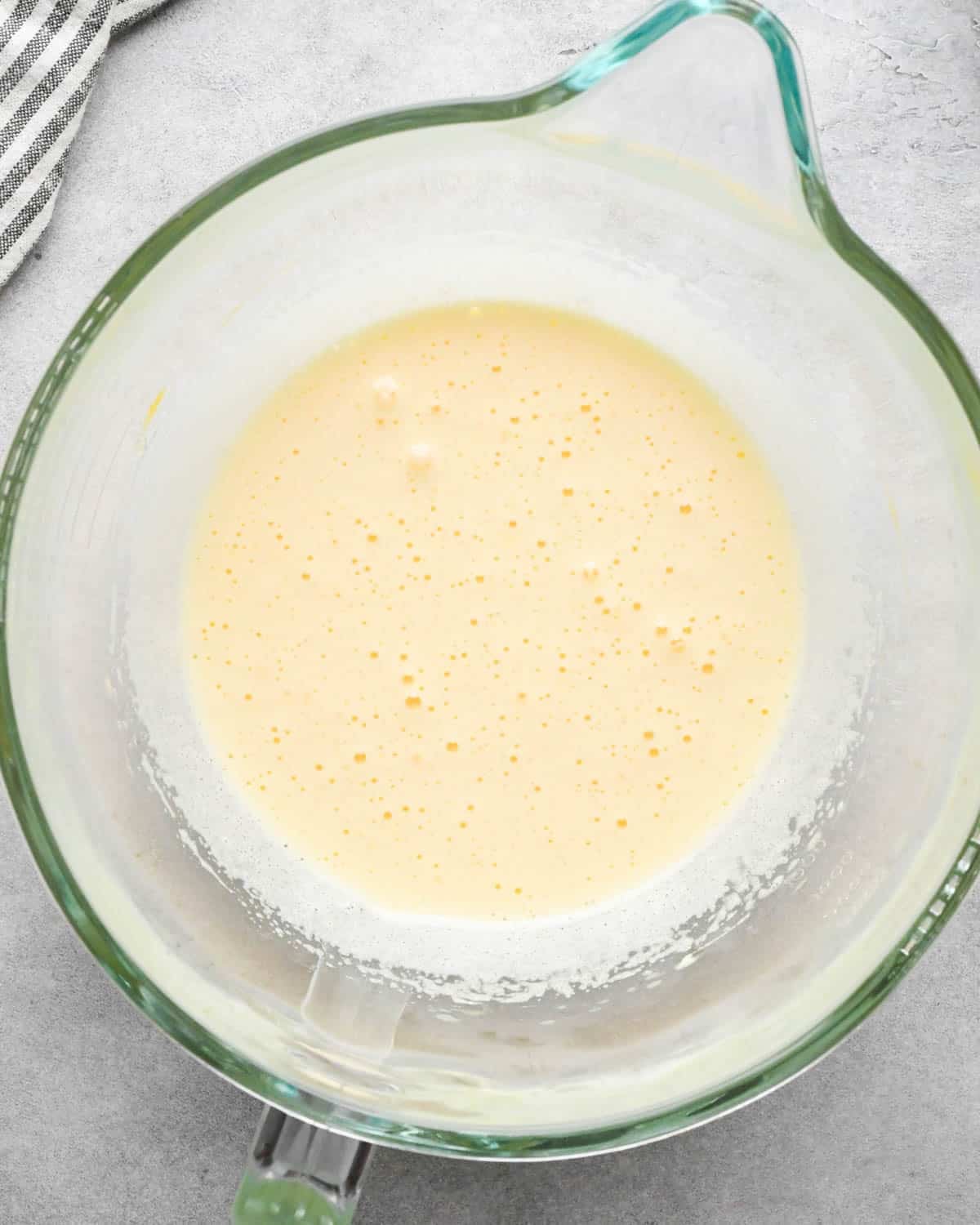 Making buckeye brownies: overhead photo of sugar and eggs beaten together in a glass measuring bowl.