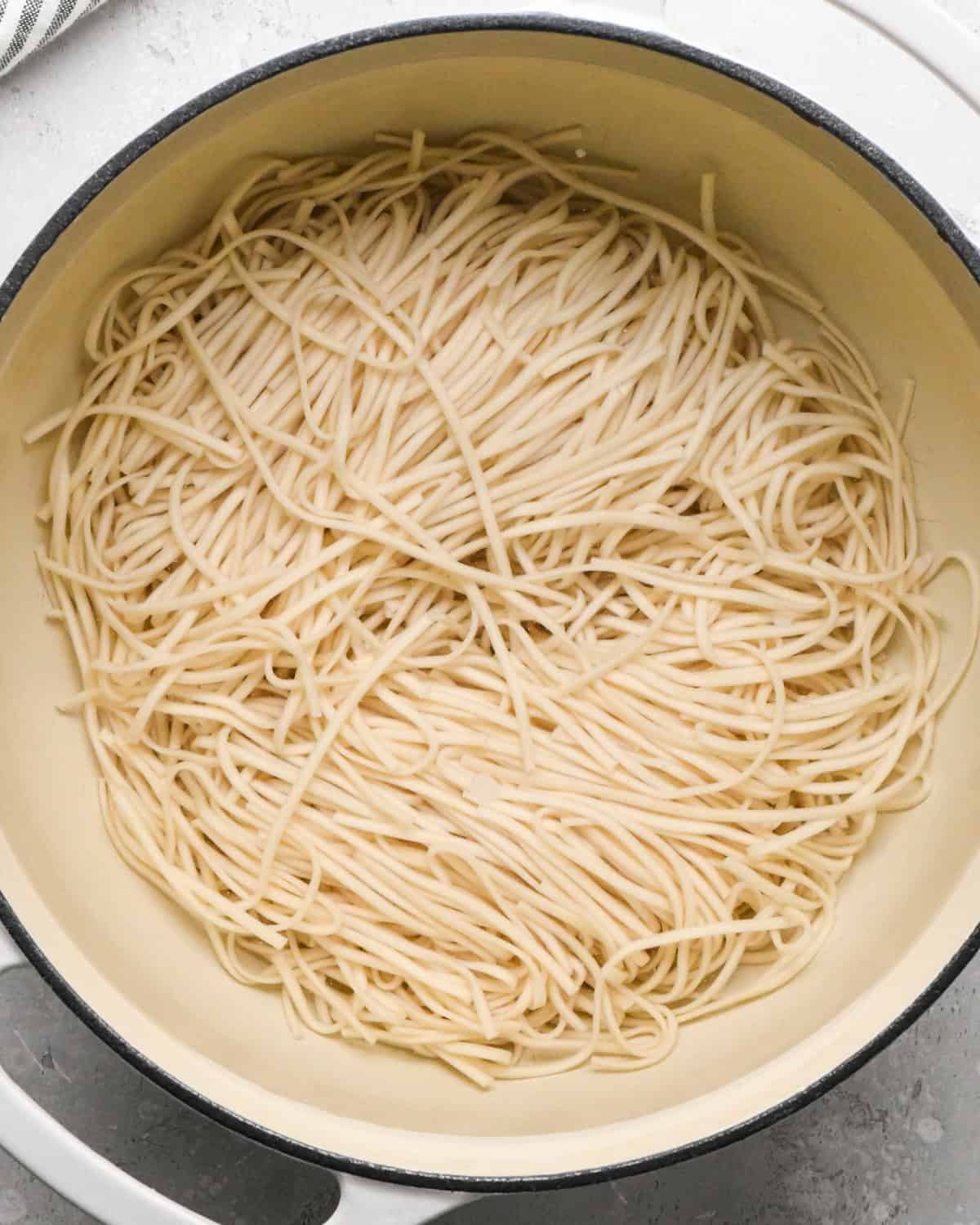 Making Pad Thai: overhead photo of cooked pasta noodles shown in a large white pot.