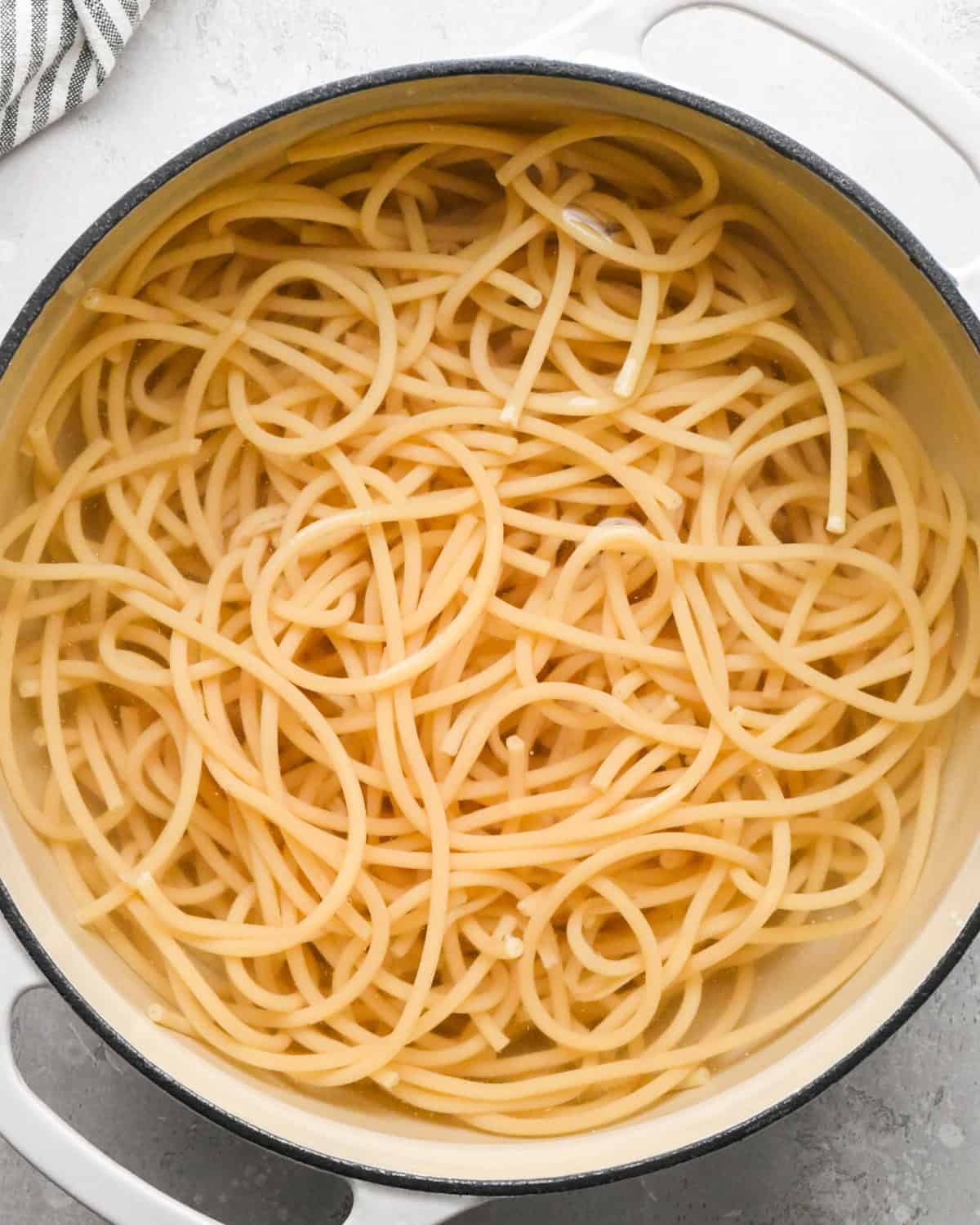 Making pasta with burrata cheese: overhead photo of cooked pasta noodles shown in a large white pot.