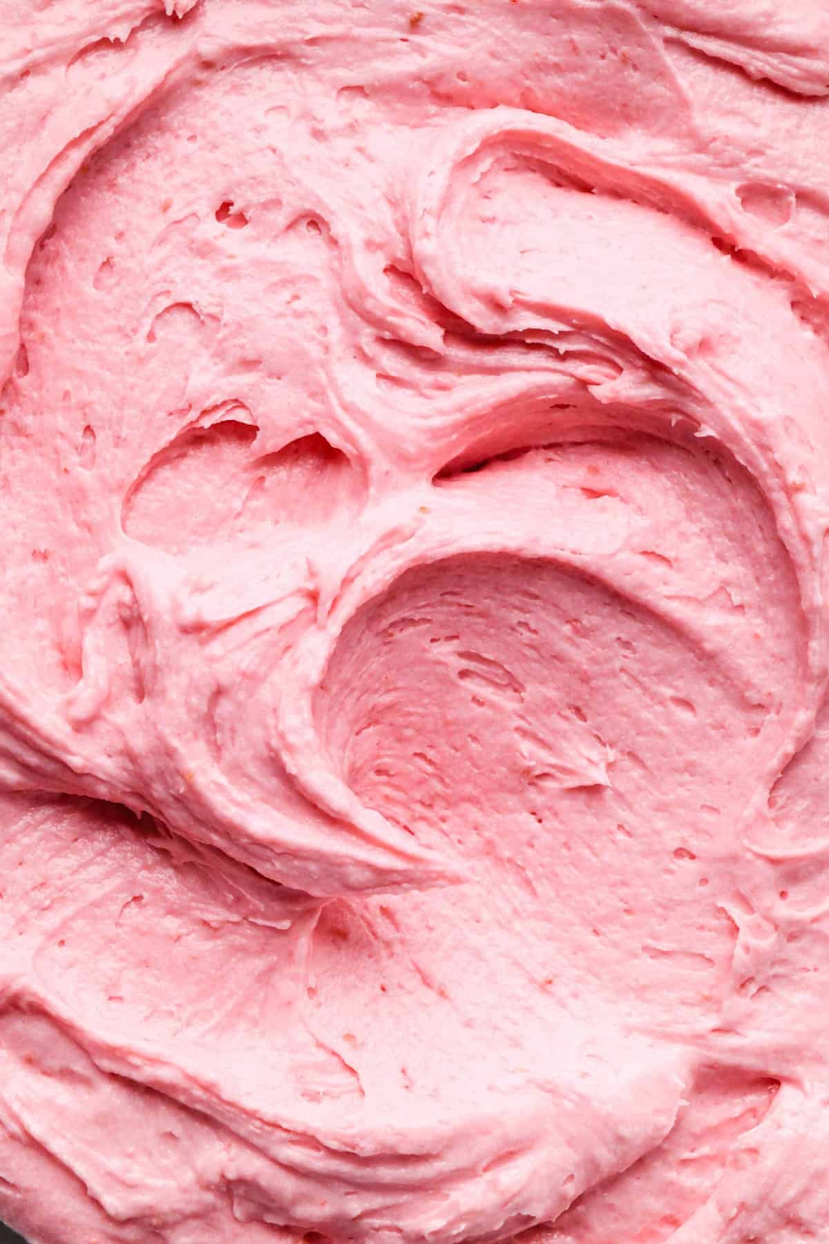 up close macro photo of swirls of raspberry buttercream frosting