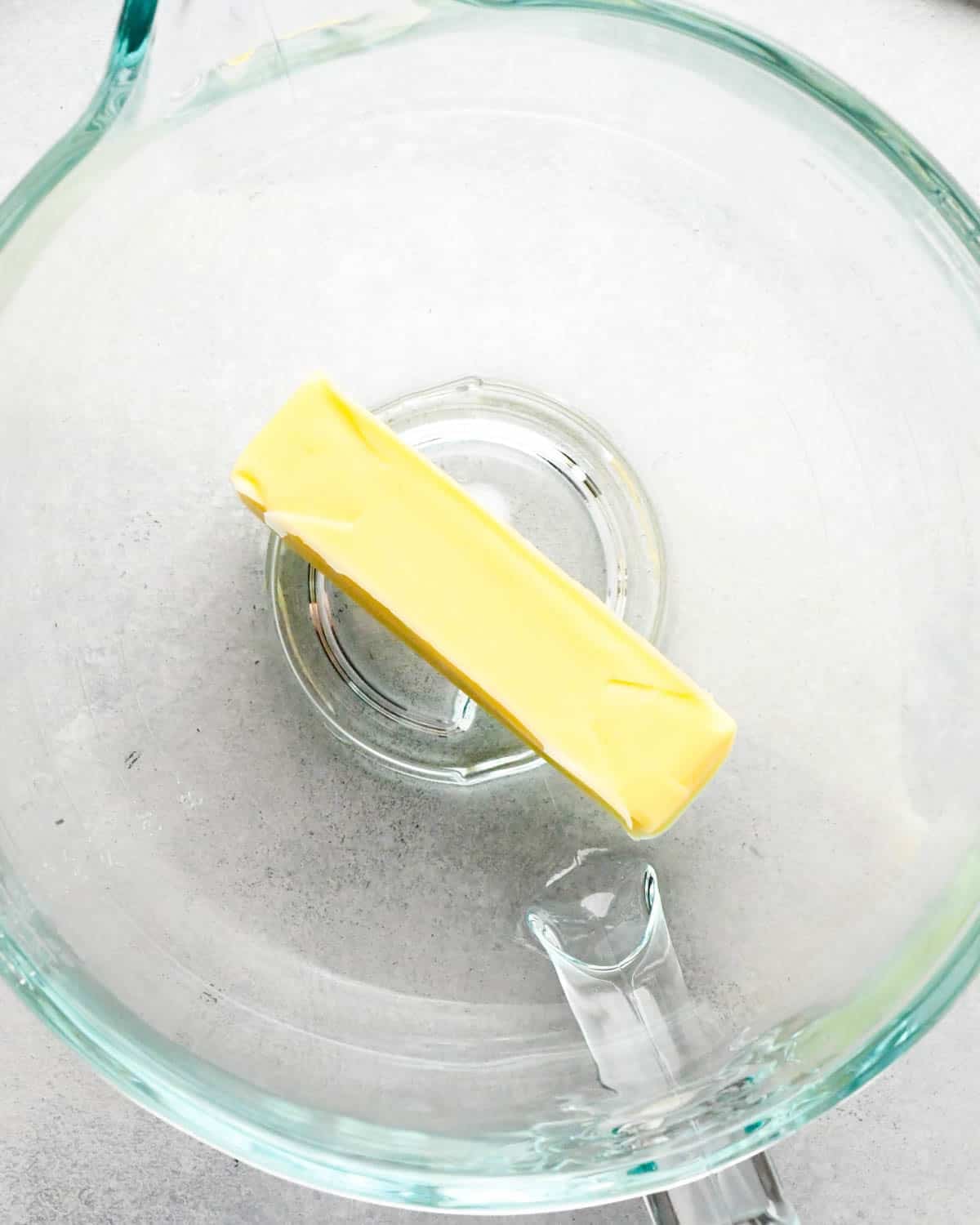 how to make raspberry frosting - a stick of butter in a glass mixing bowl