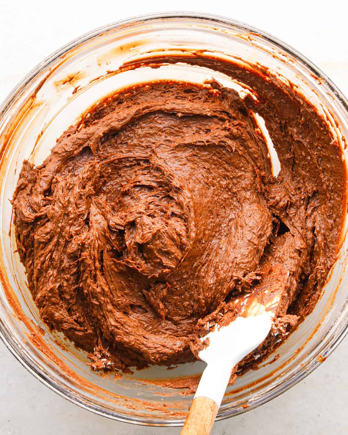 making coconut brownies - shredded coconut mixed into to the brownie batter in a glass bowl