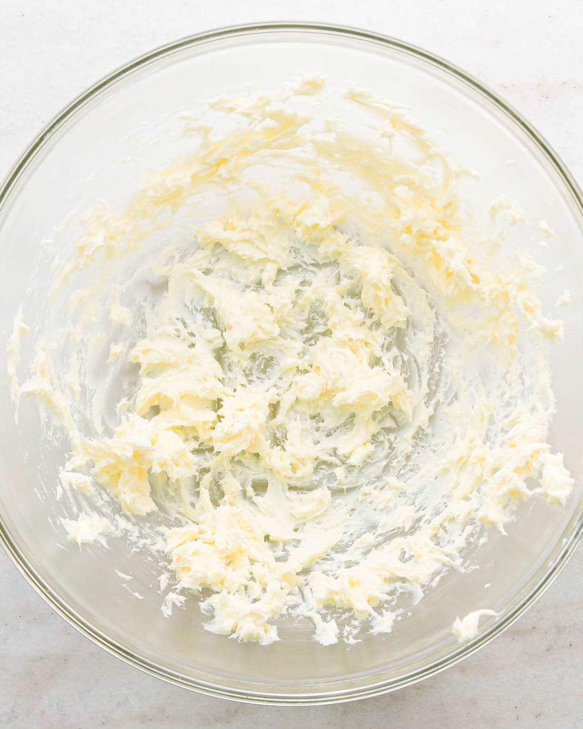 a stick of butter in a glass bowl after it has been beaten